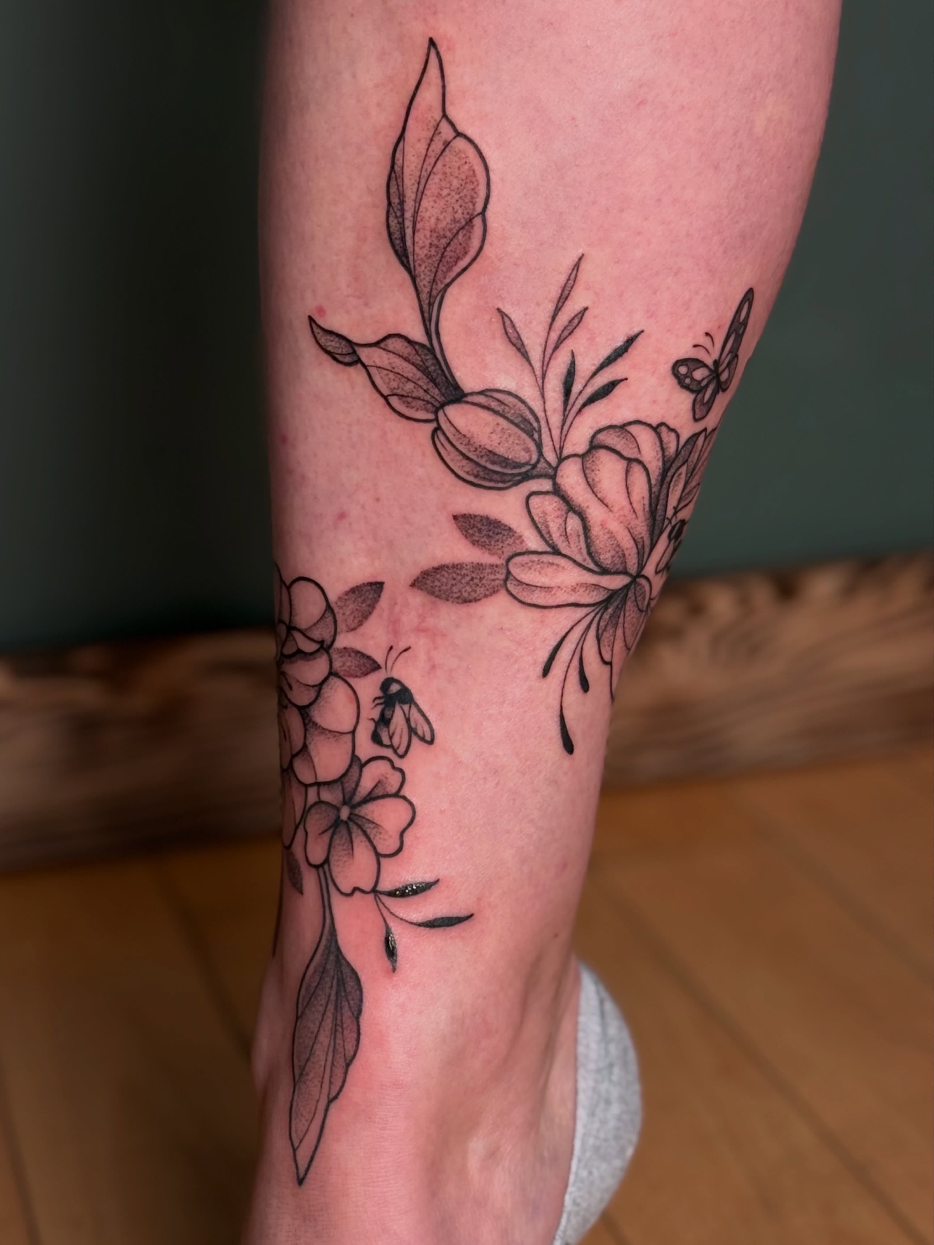 Floral arrangement black and grey tattoo on the calf by Emma Friesen - Lancaster & York Tattoo Artist, Lancaster, Pennsylvania