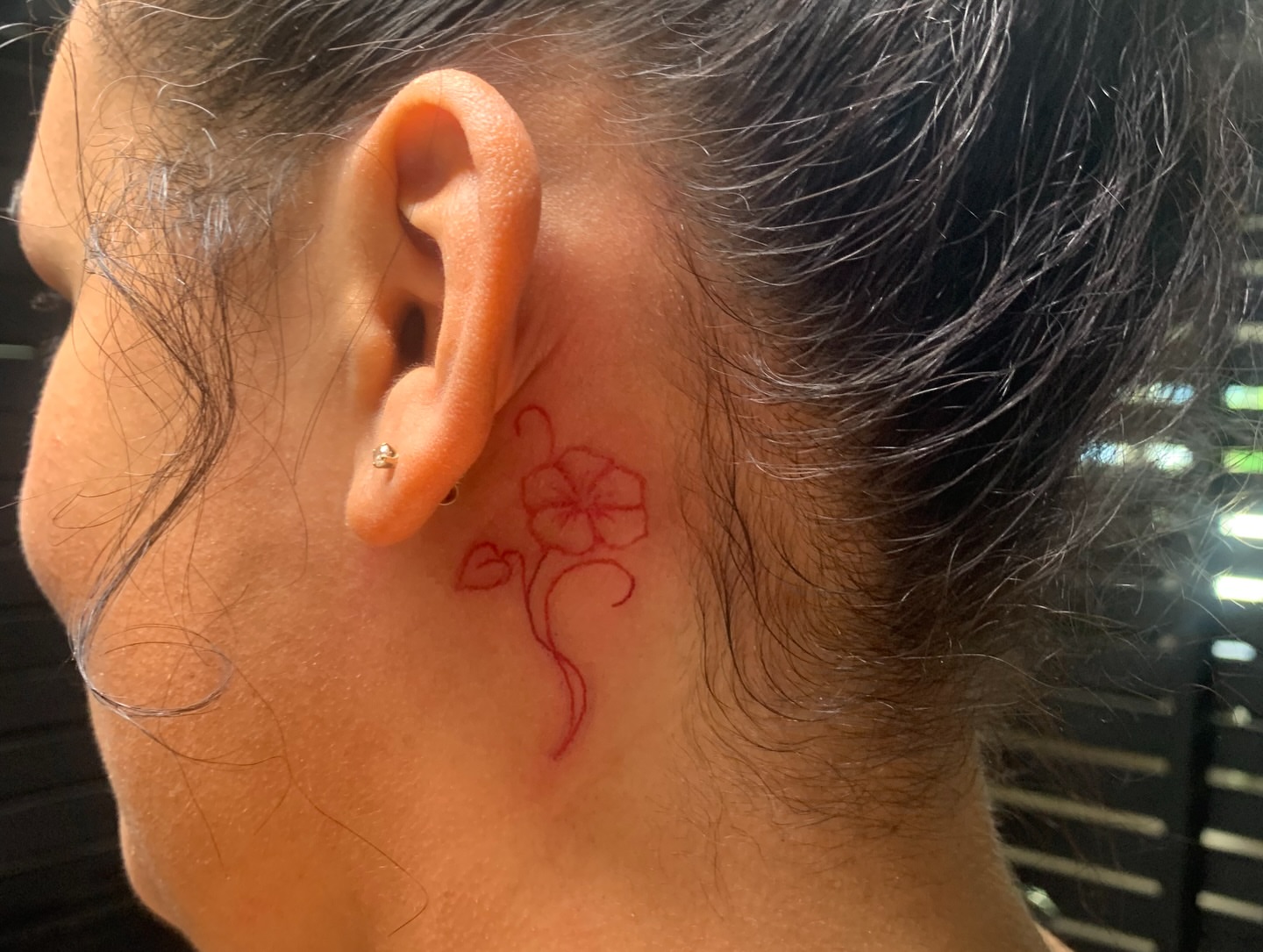 Flower fine line tattoo on the neck by Sam Ingalls