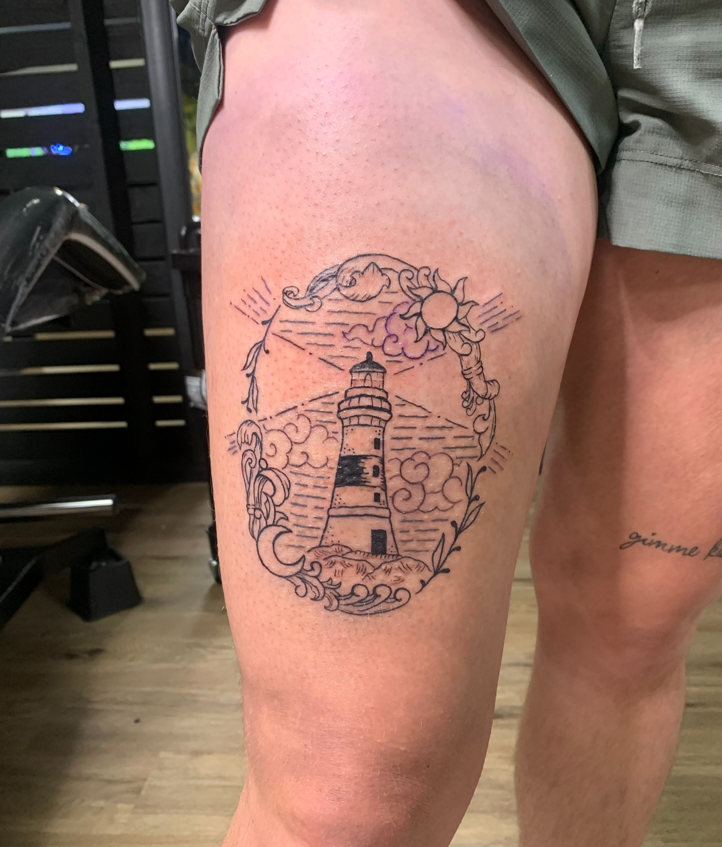 Lighthouse black and grey tattoo on the thigh by Sam Ingalls