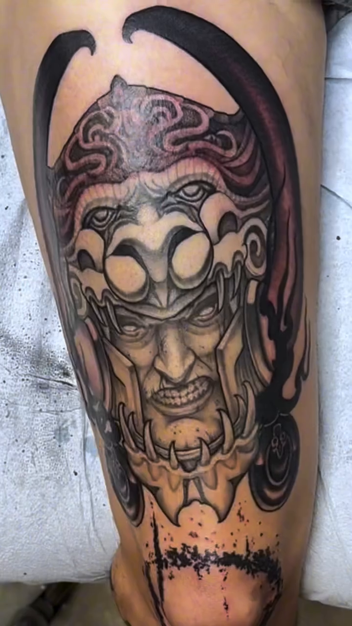 Demonic face with ornate headpiece Japanese tattoo on the leg by Michael Bogle