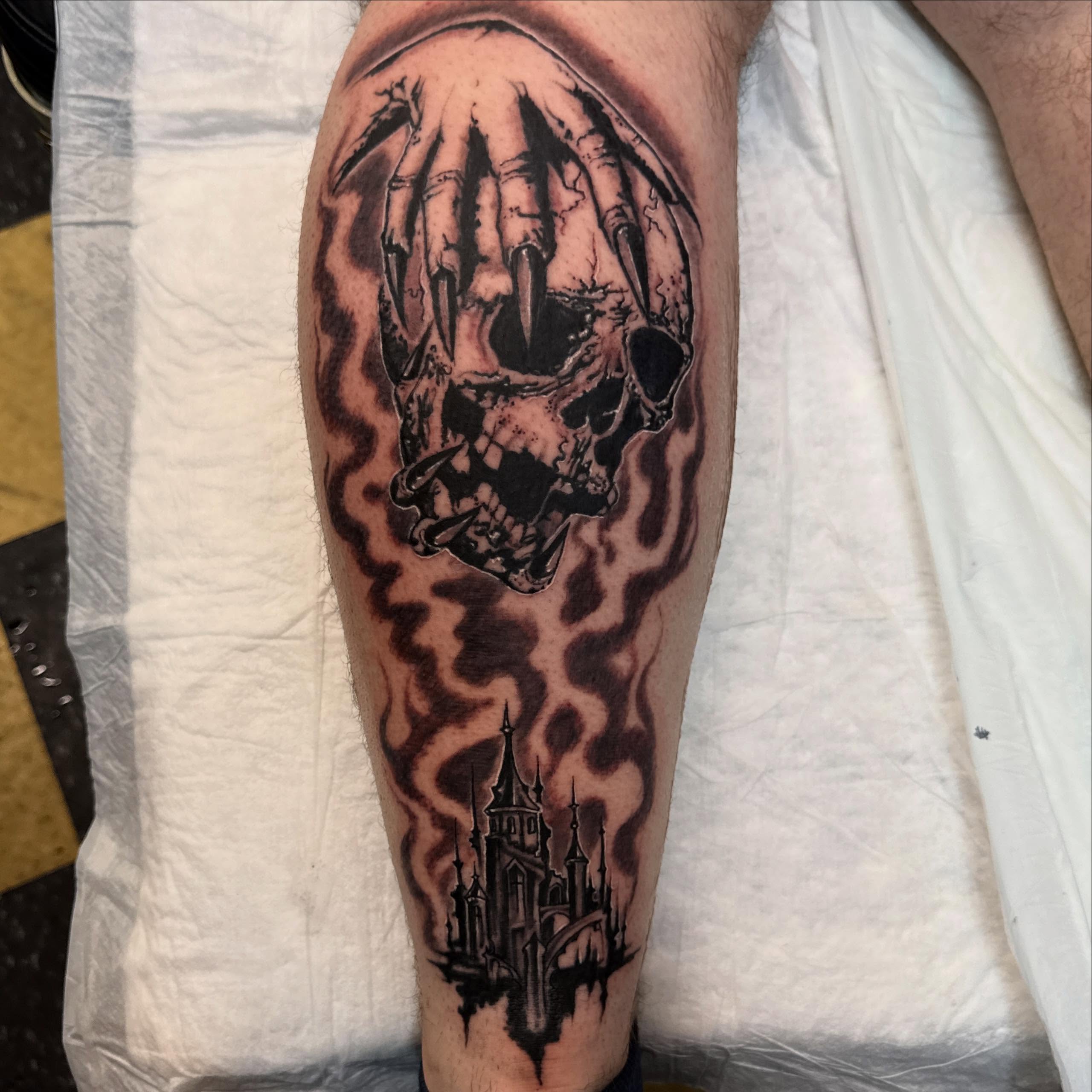 Skull and castle dark realism tattoo on the forearm by Gary Chase