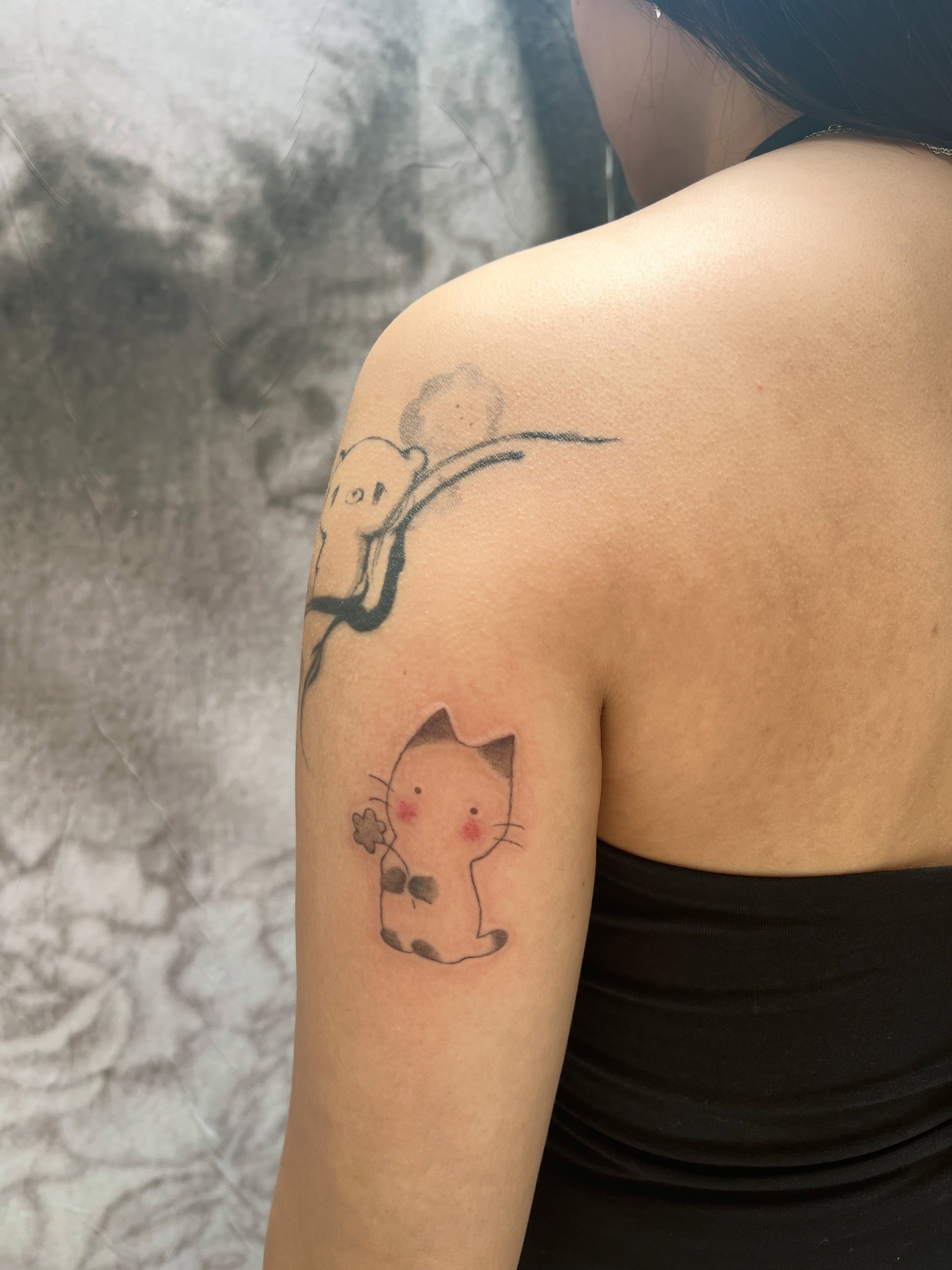 Cat and bear black and grey tattoo on the shoulder by Kyra Monterrosa