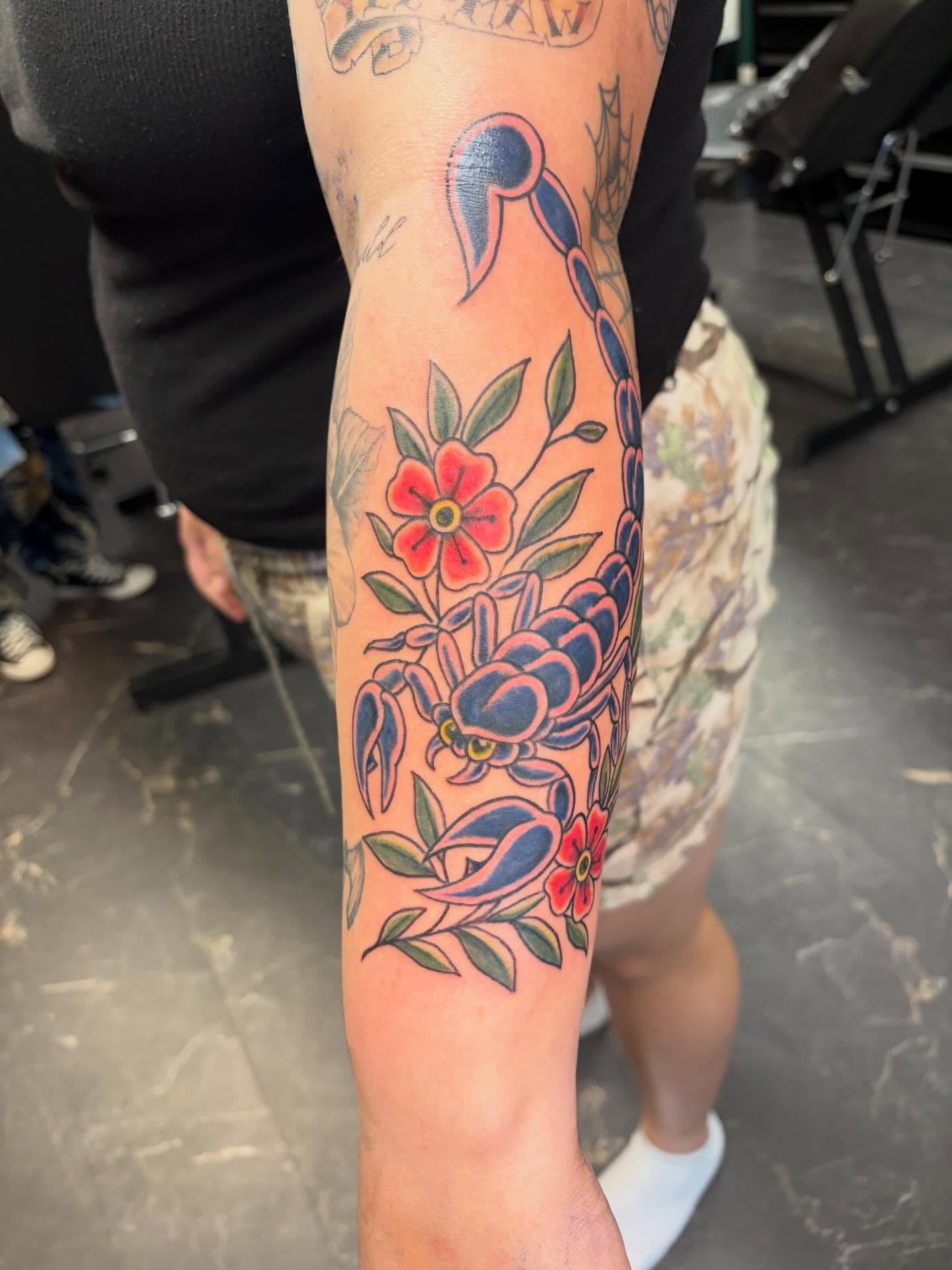 Scorpion and flowers American traditional tattoo on the forearm by Fredrick Tigerman