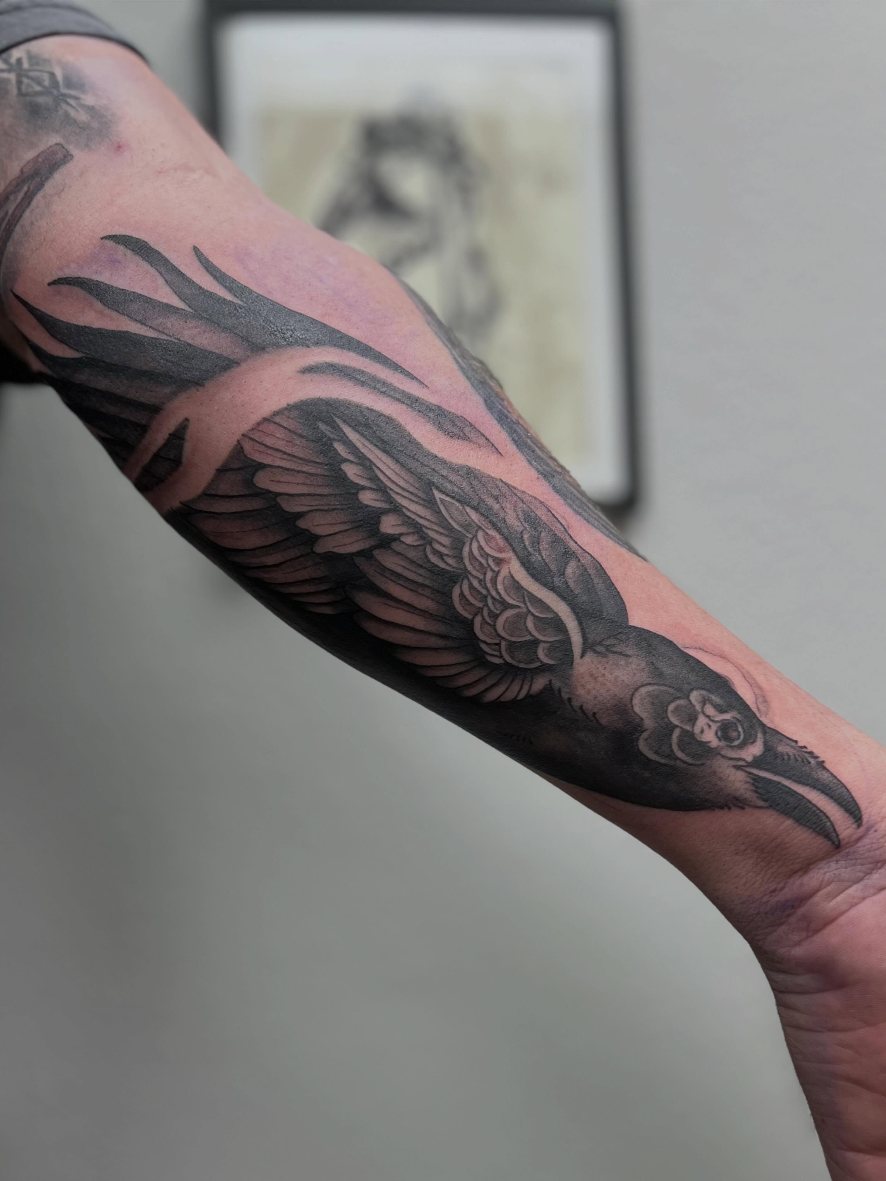 Crow black and grey tattoo on the forearm by Rebecca Kern Tattoos
