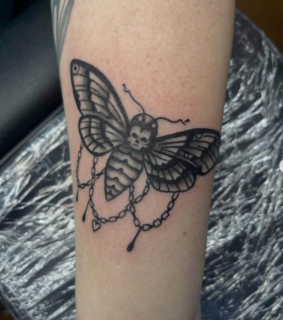 Butterfly with skull black and grey tattoo on the forearm by Thomas Gredig