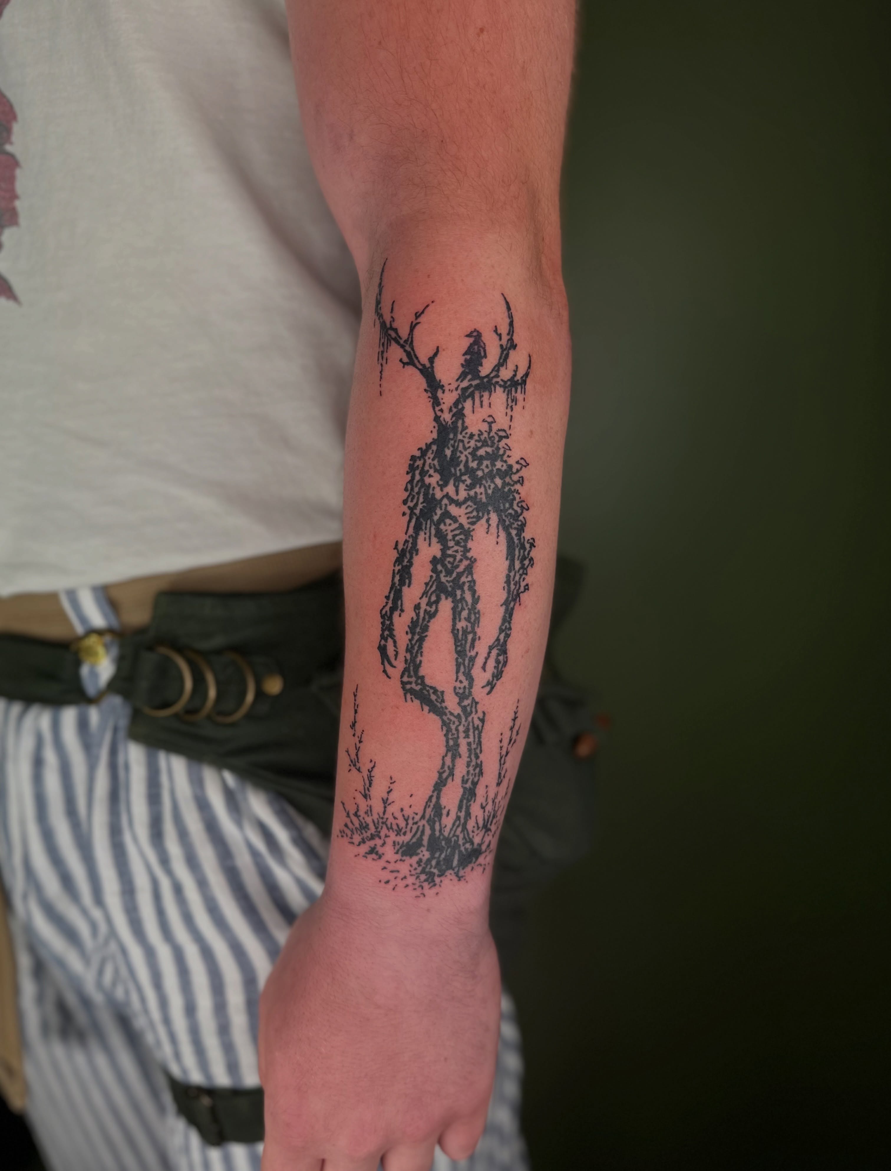 Tree-like creature black and grey tattoo on the forearm by Nikolas Tapio Aatos Mäkelä