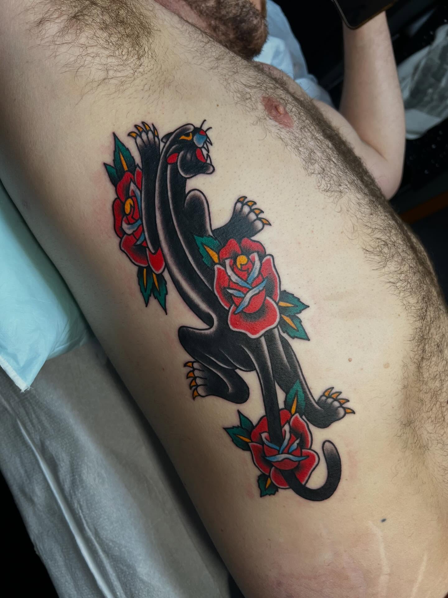 Panther and roses American traditional tattoo on the thigh by Tyler Van Pelt