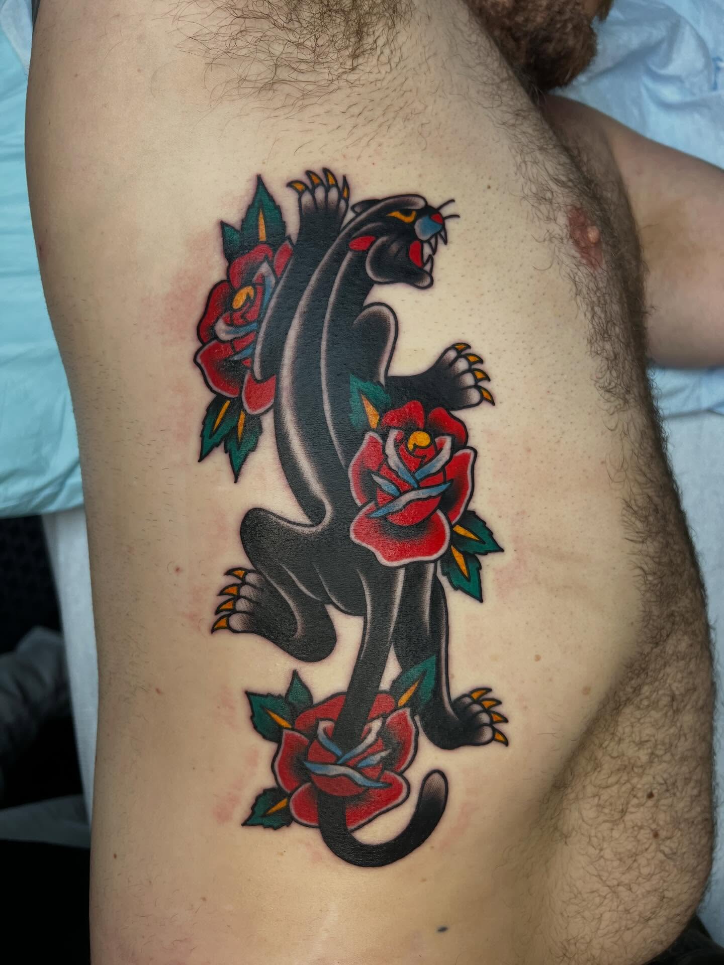 Panther and roses American traditional tattoo on the ribs by Tyler Van Pelt