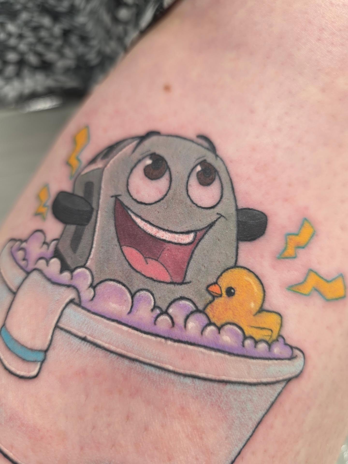 Bathtub scene new school tattoo on the upper arm by Mandy Rizzuto