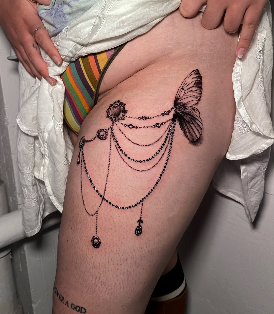 Butterfly wing and jewelry ornamental tattoo on the thigh by kale