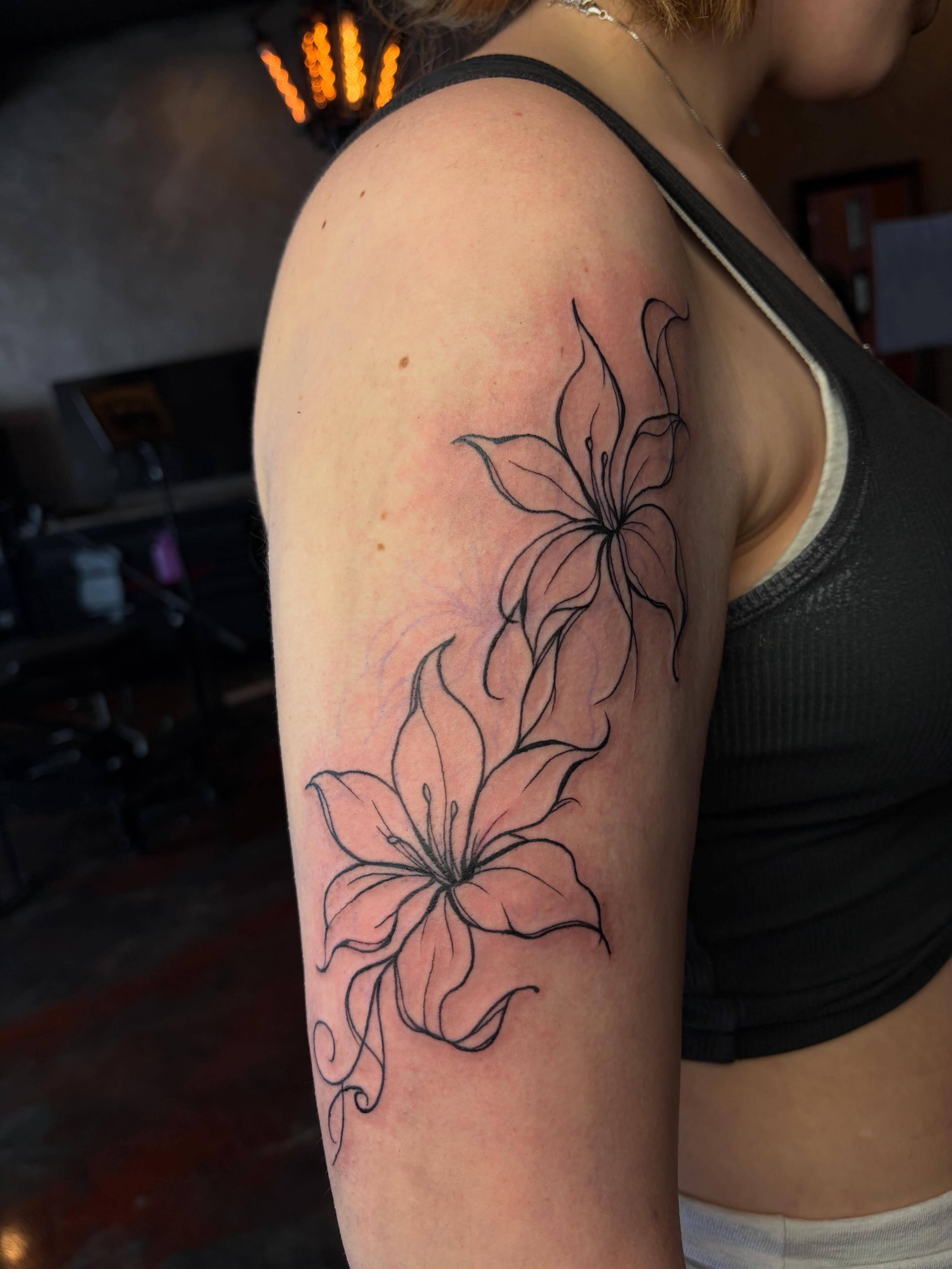 Lilies black and grey tattoo on the upper arm by destany aguilera, Davenport, Iowa