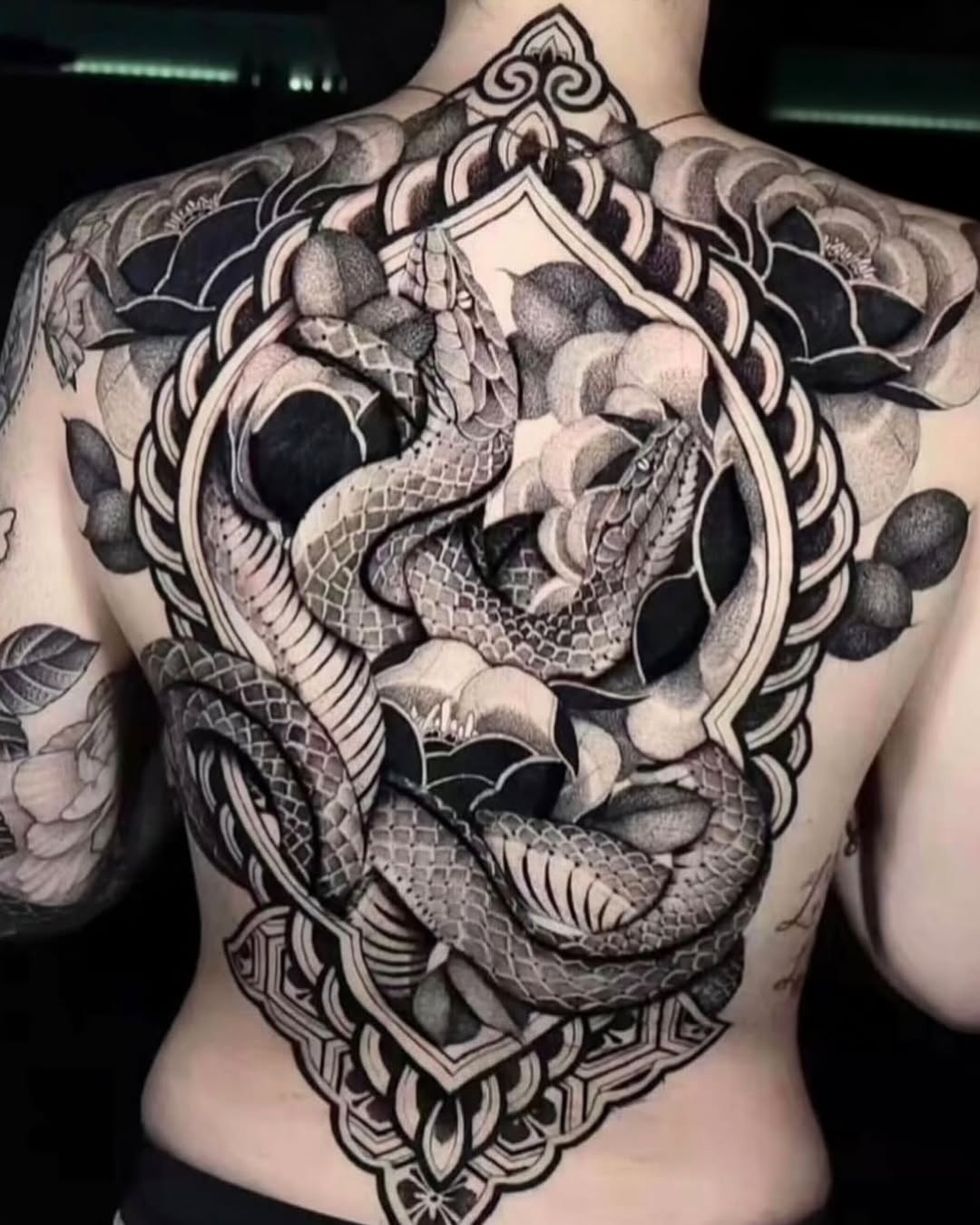 Two snakes and floral elements geometric tattoo on the back by miami tattoo artist