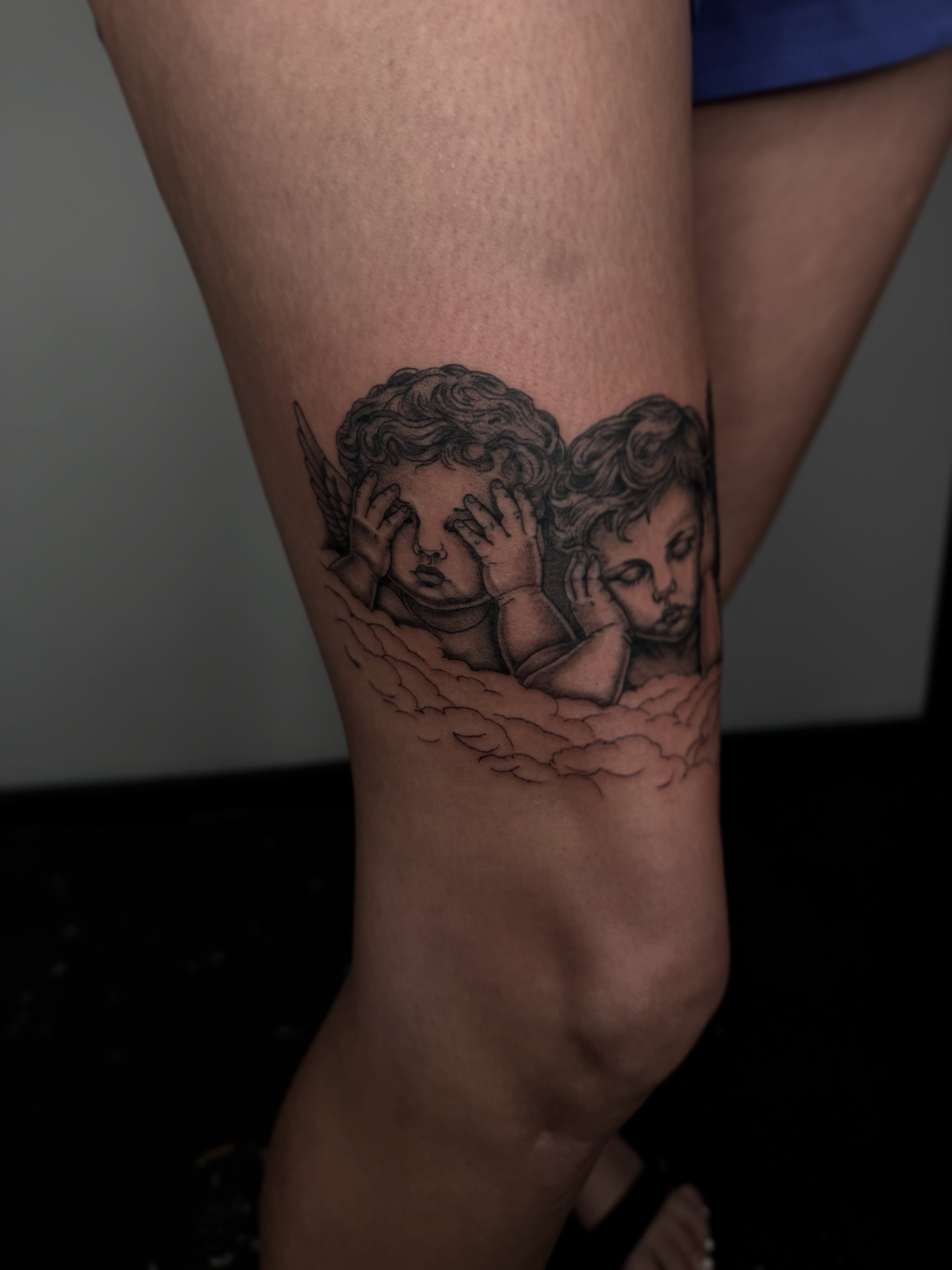 Angels black and grey tattoo on the thigh by Brandon Shelby