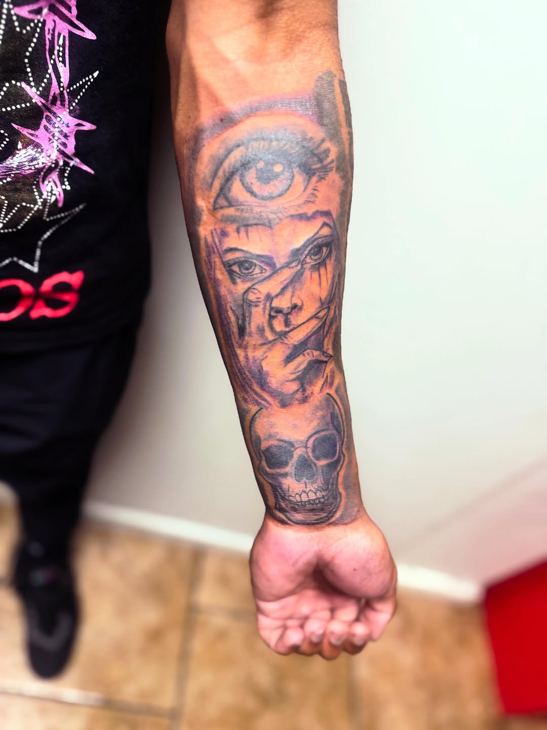 Eye, face, and skull realism tattoo on the forearm by Uncle Fade Tattoo Artist ✍🏾