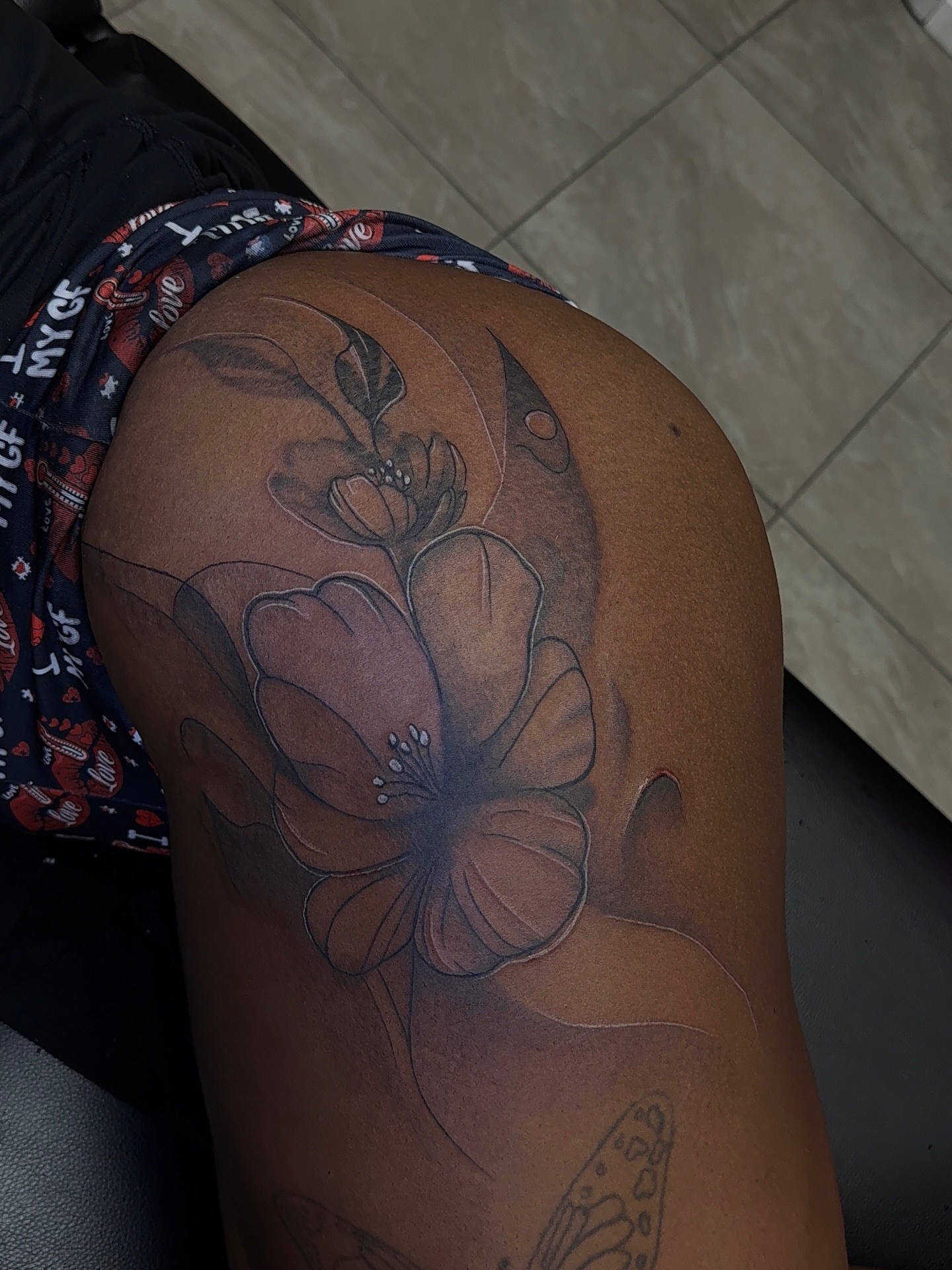 Flower black and grey tattoo on the thigh by XoticTherapy, Las Vegas, Nevada