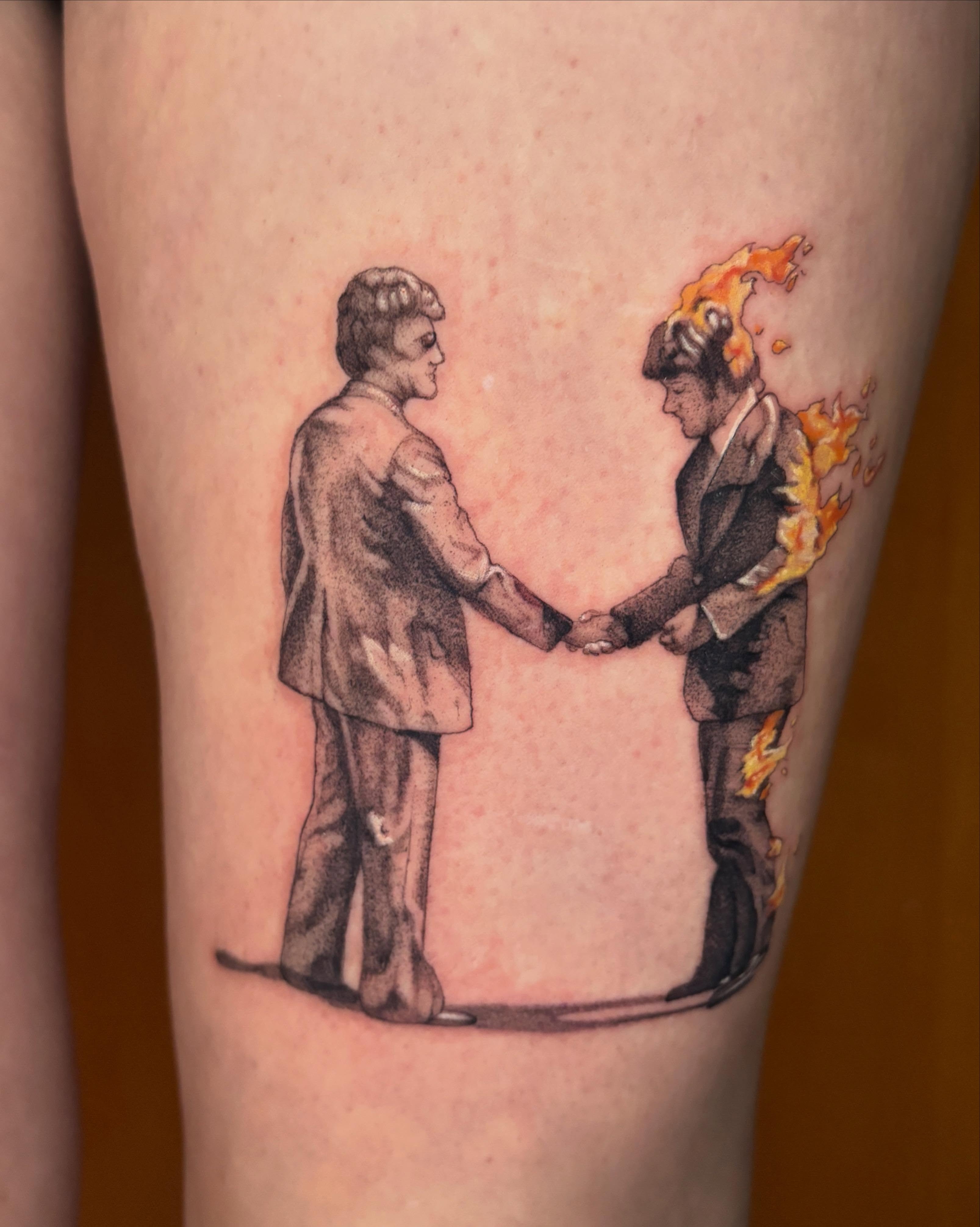 Handshake black and grey tattoo on the thigh by Autumn
