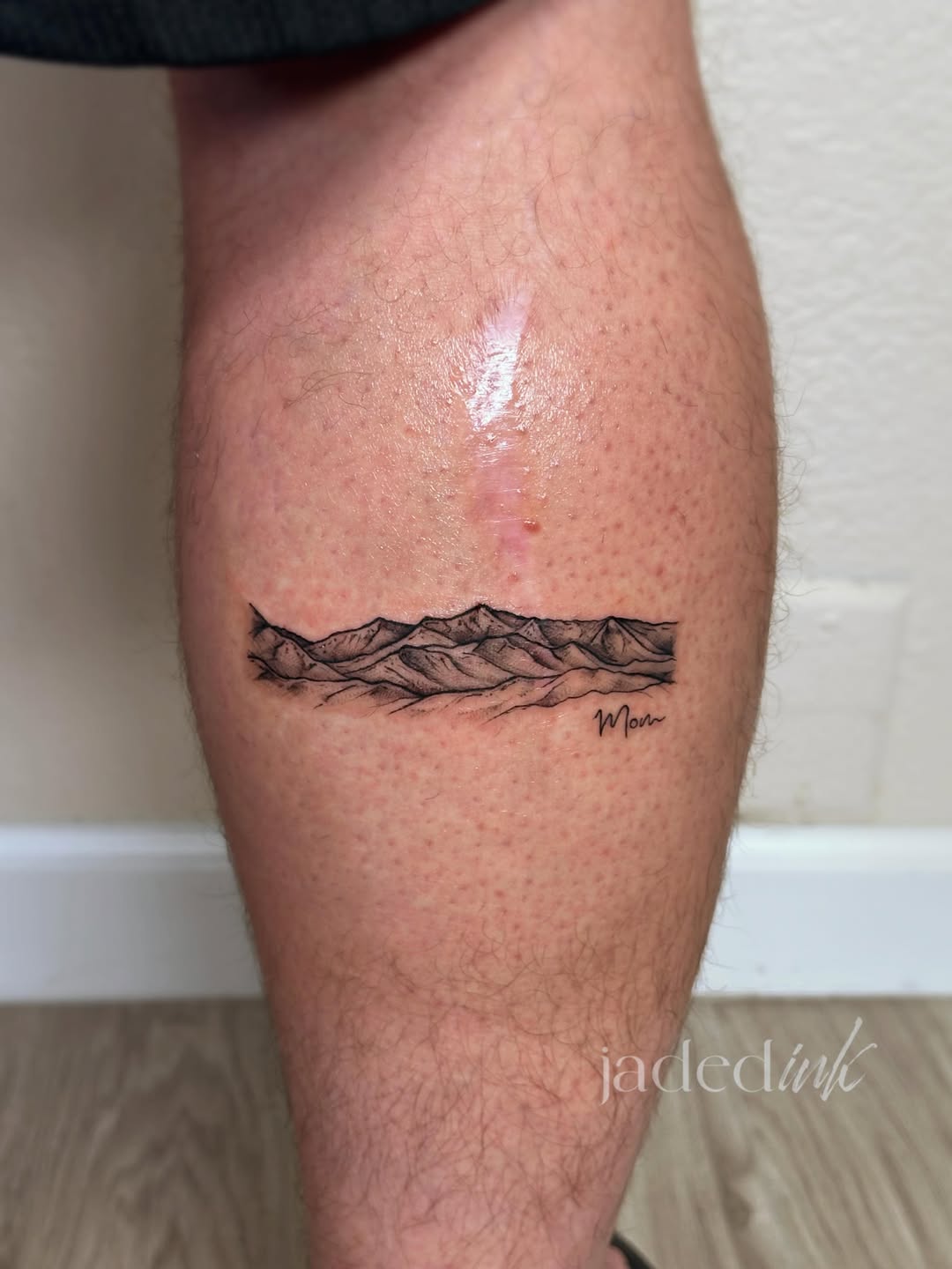 Mountain range and text fine line tattoo on the calf by 𝑱𝒂𝒅𝒆𝒅 𝑰𝒏𝒌 𝑷𝒆𝒓𝒎𝒂𝒏𝒆𝒏𝒕 𝑴𝒂𝒌𝒆𝒖𝒑 & 𝑻𝒂𝒕𝒕𝒐𝒐