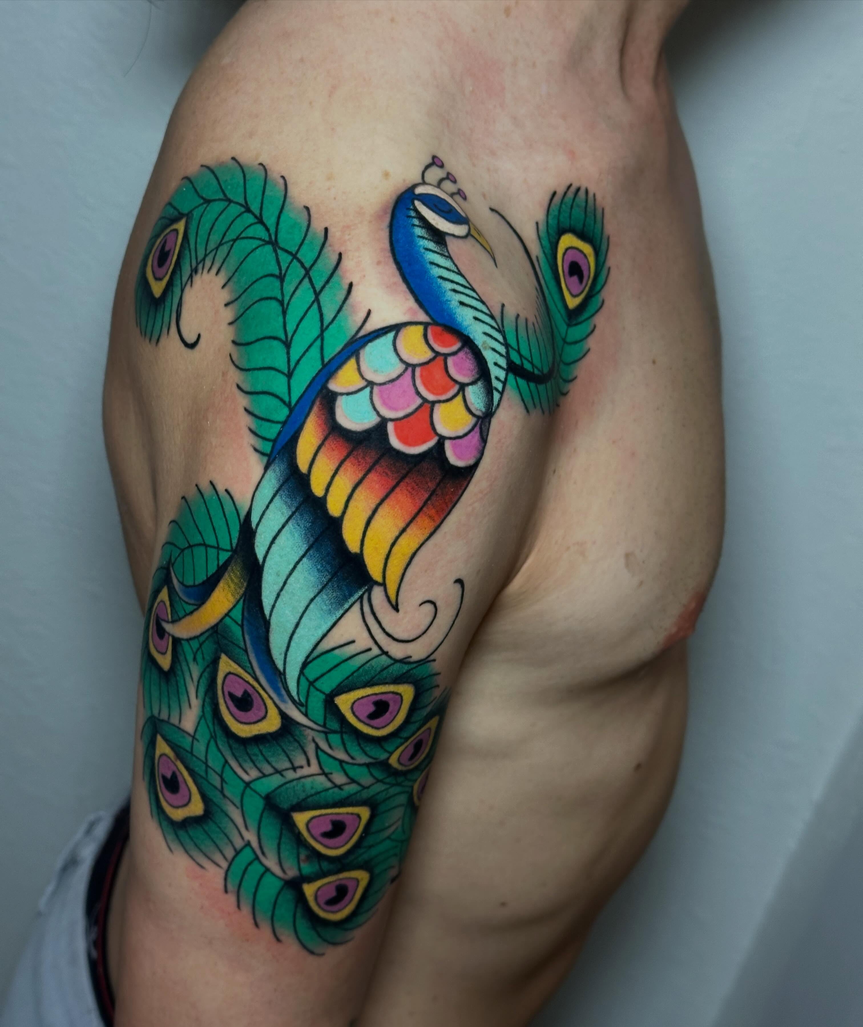 Peacock new school tattoo on the thigh by Liz McDonald