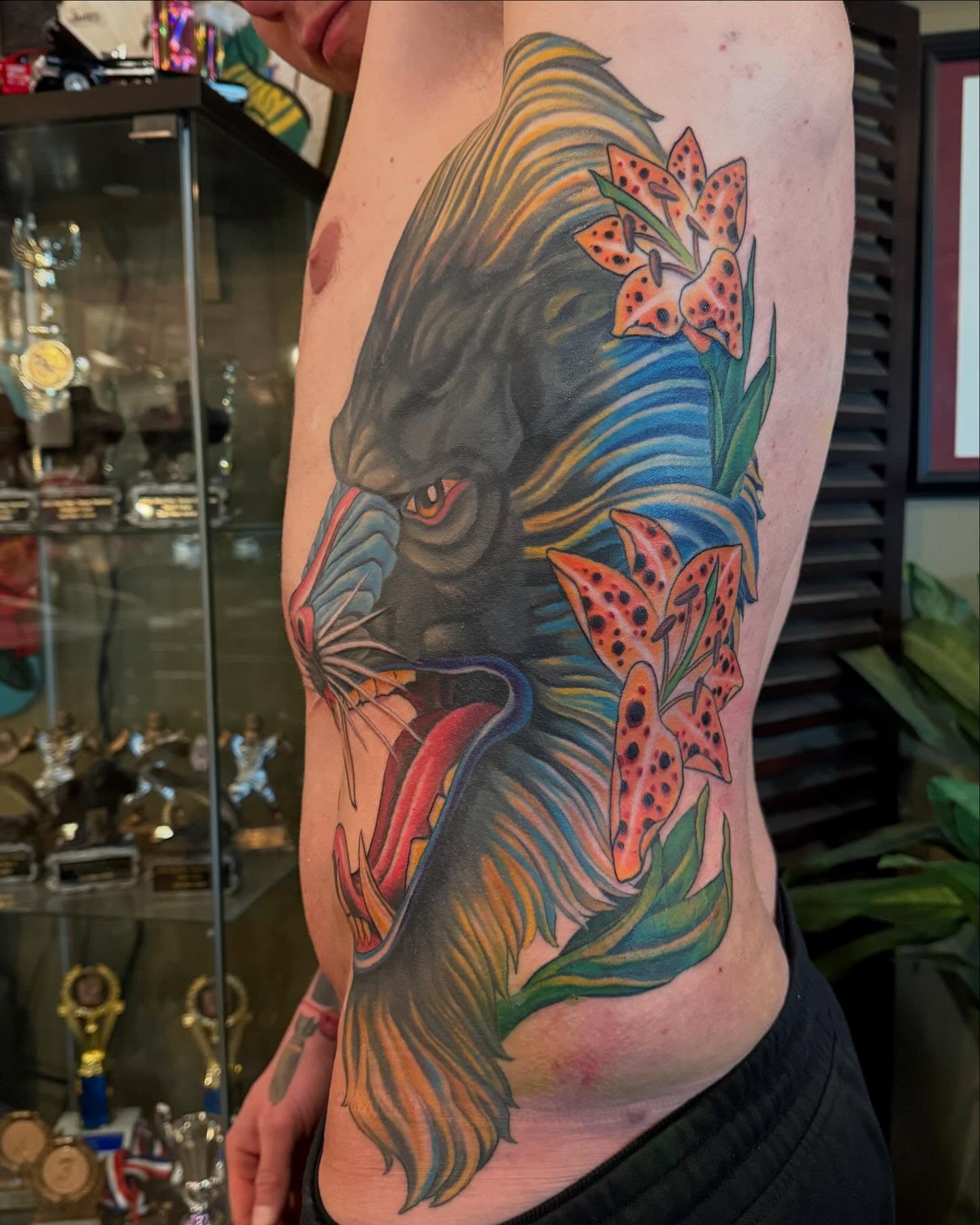 Lion and lilies realism tattoo on the ribs by Jesse Gray