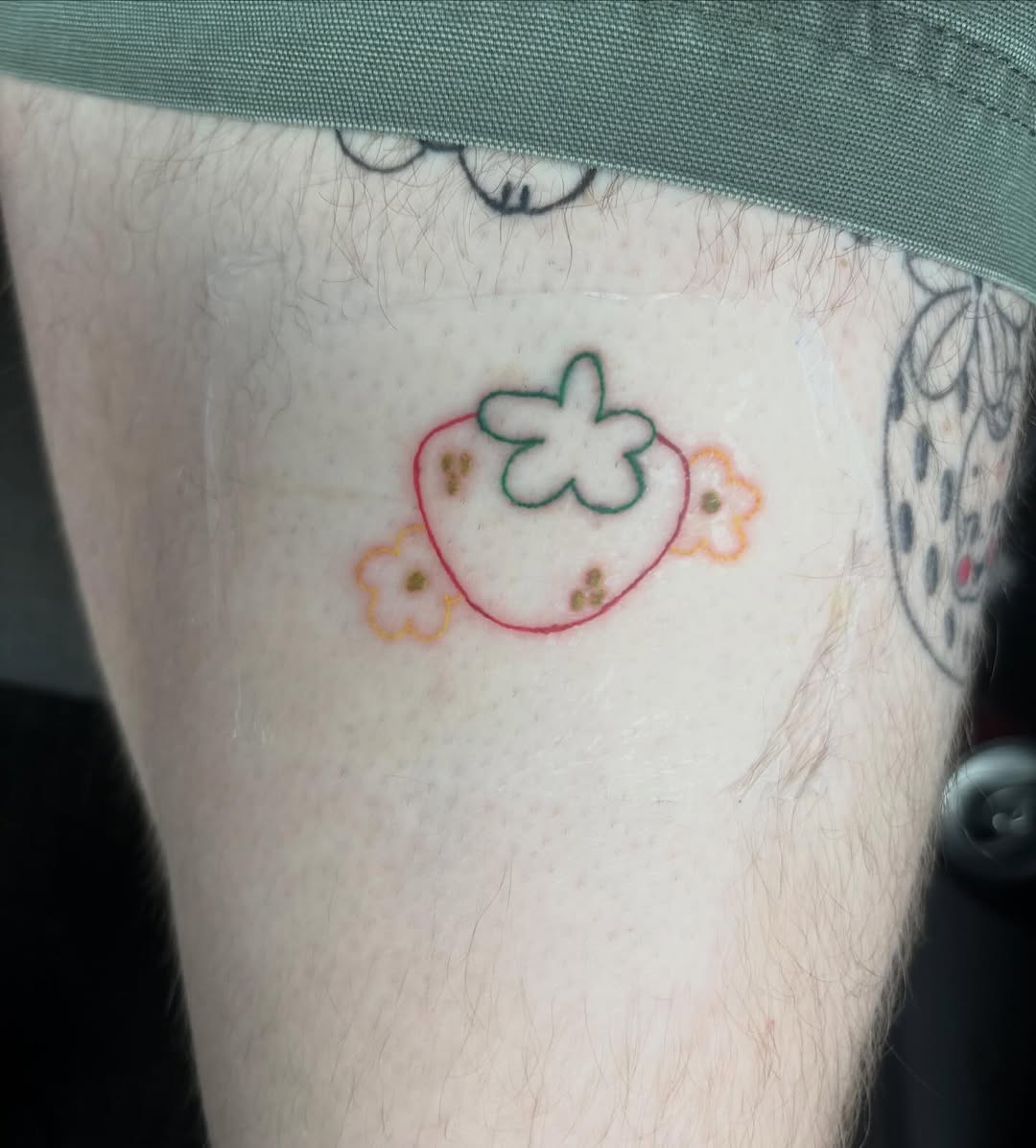 Strawberry and flowers new school tattoo on the forearm by riley