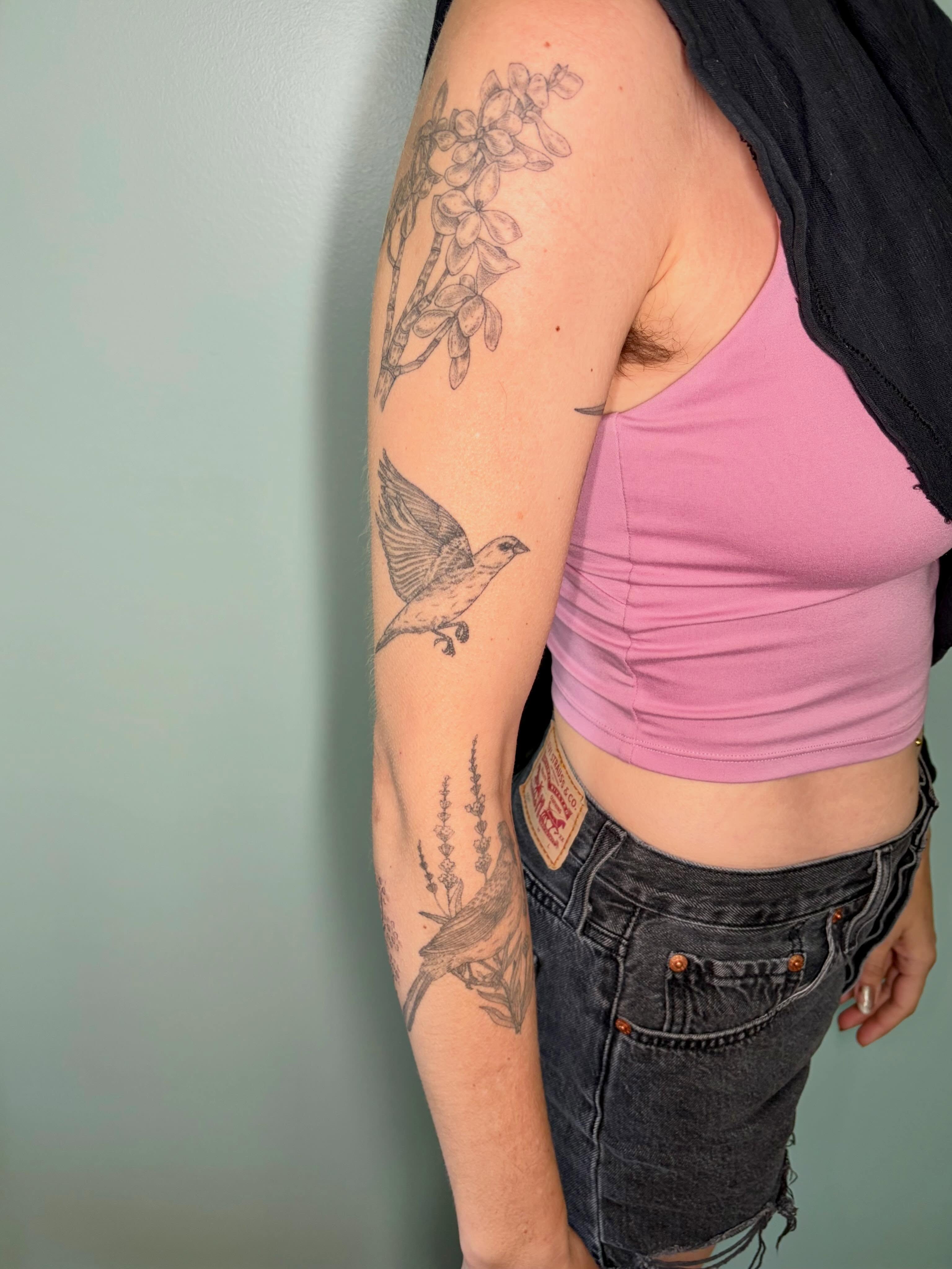 Bird and flowers black and grey tattoo on the forearm by Sarah Roach