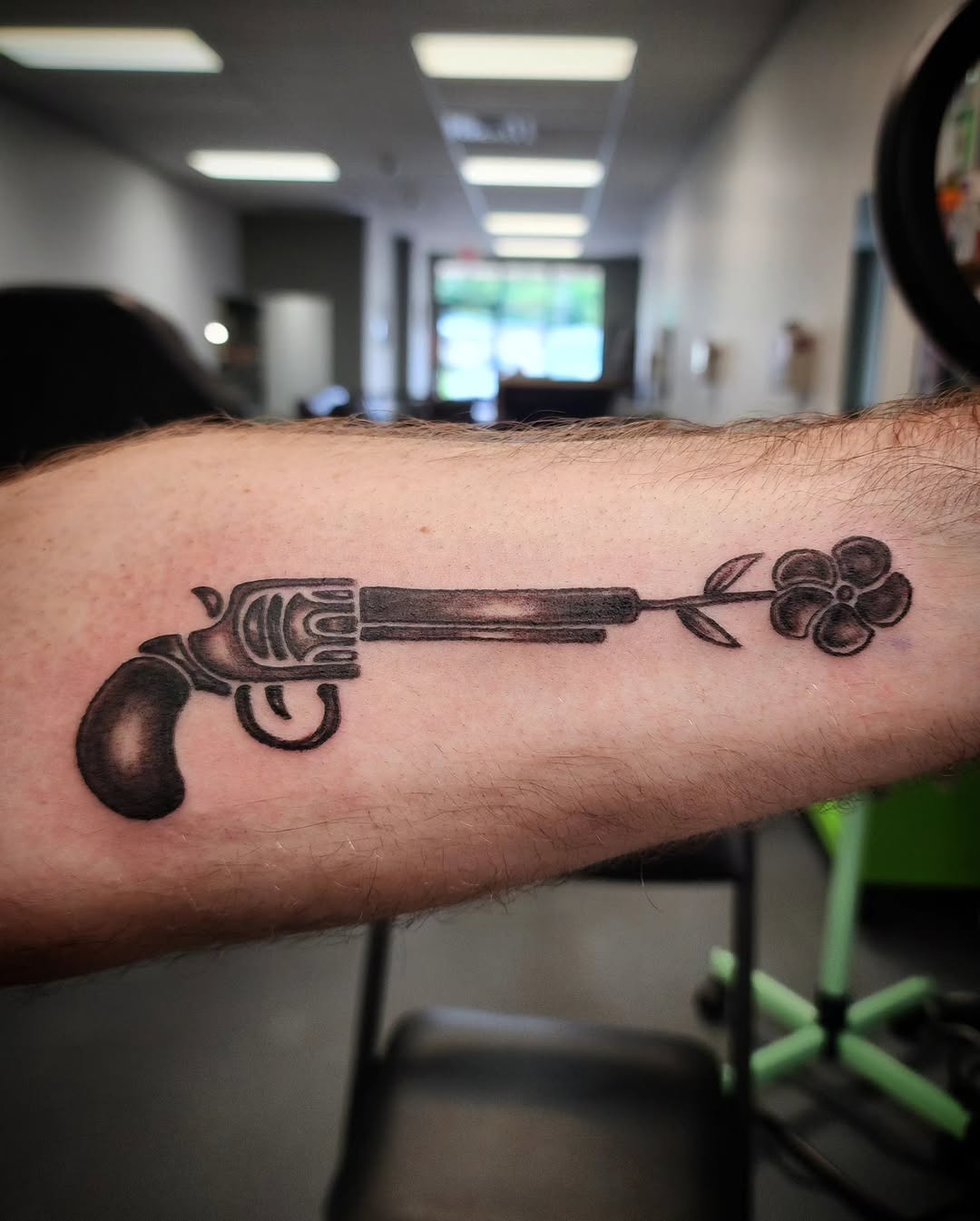 Gun with flower tattoo on the forearm by Anntonietta Borzacchiello