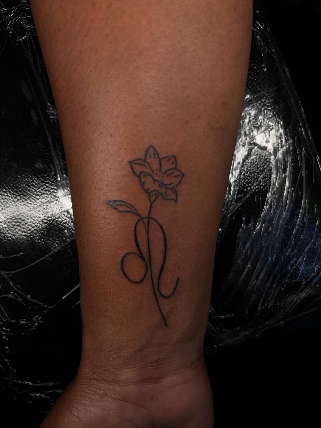 Flower and leo symbol fine line tattoo on the forearm by Pres!