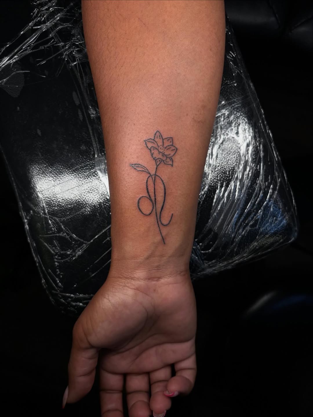 Flower and leo symbol fine line tattoo on the forearm by Pres!