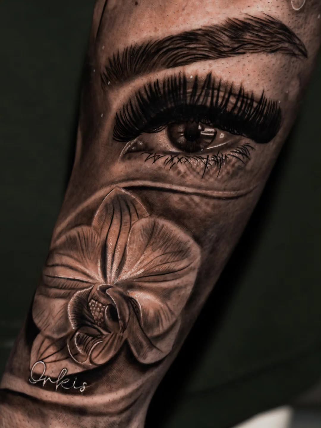 Eye and orchid realism tattoo on the forearm by Baxtertattoo