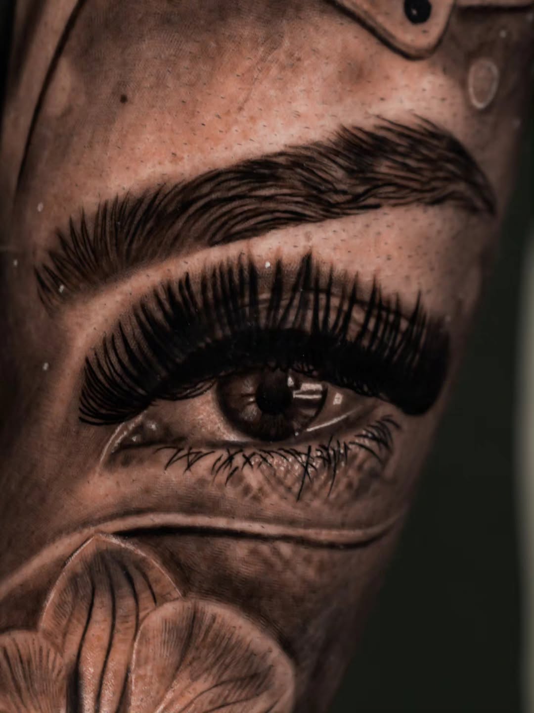 Eye and flower realism tattoo on the forearm by Baxtertattoo