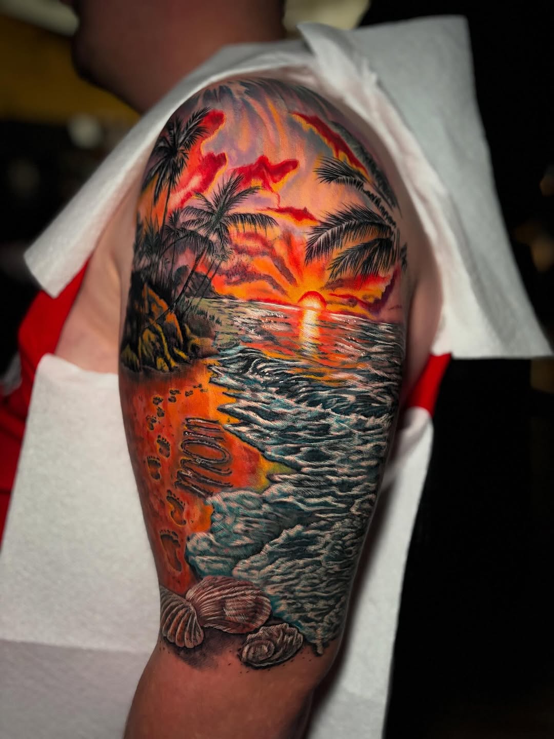 Tropical sunset beach scene realism tattoo on the forearm by Ashley Denise