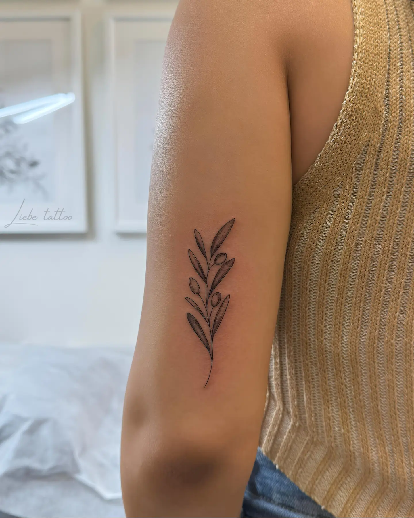 Olive branch black and grey tattoo on the forearm by Floral Fineline Tattoo