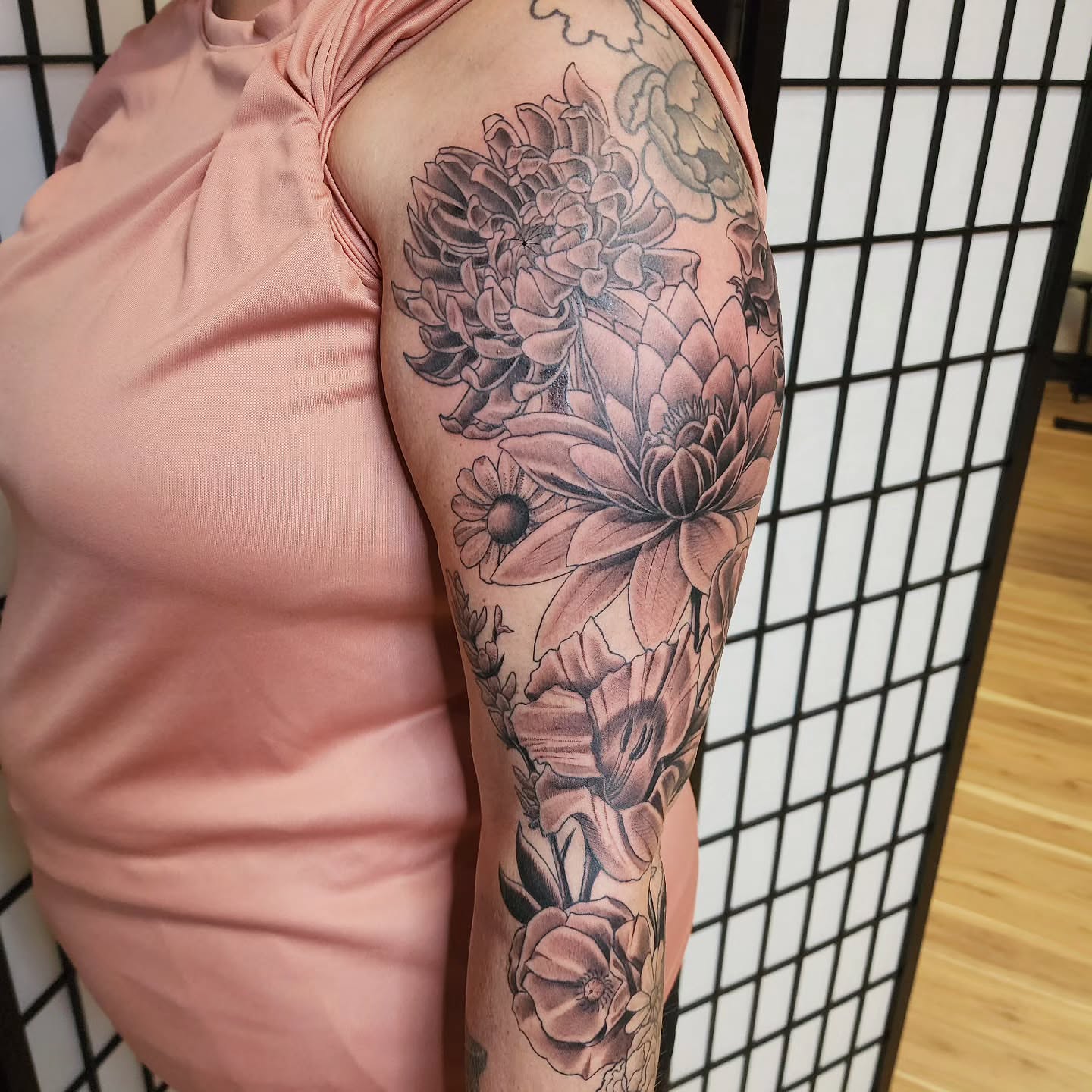 Floral arrangement black and grey tattoo on the upper arm by Anthony Moncada