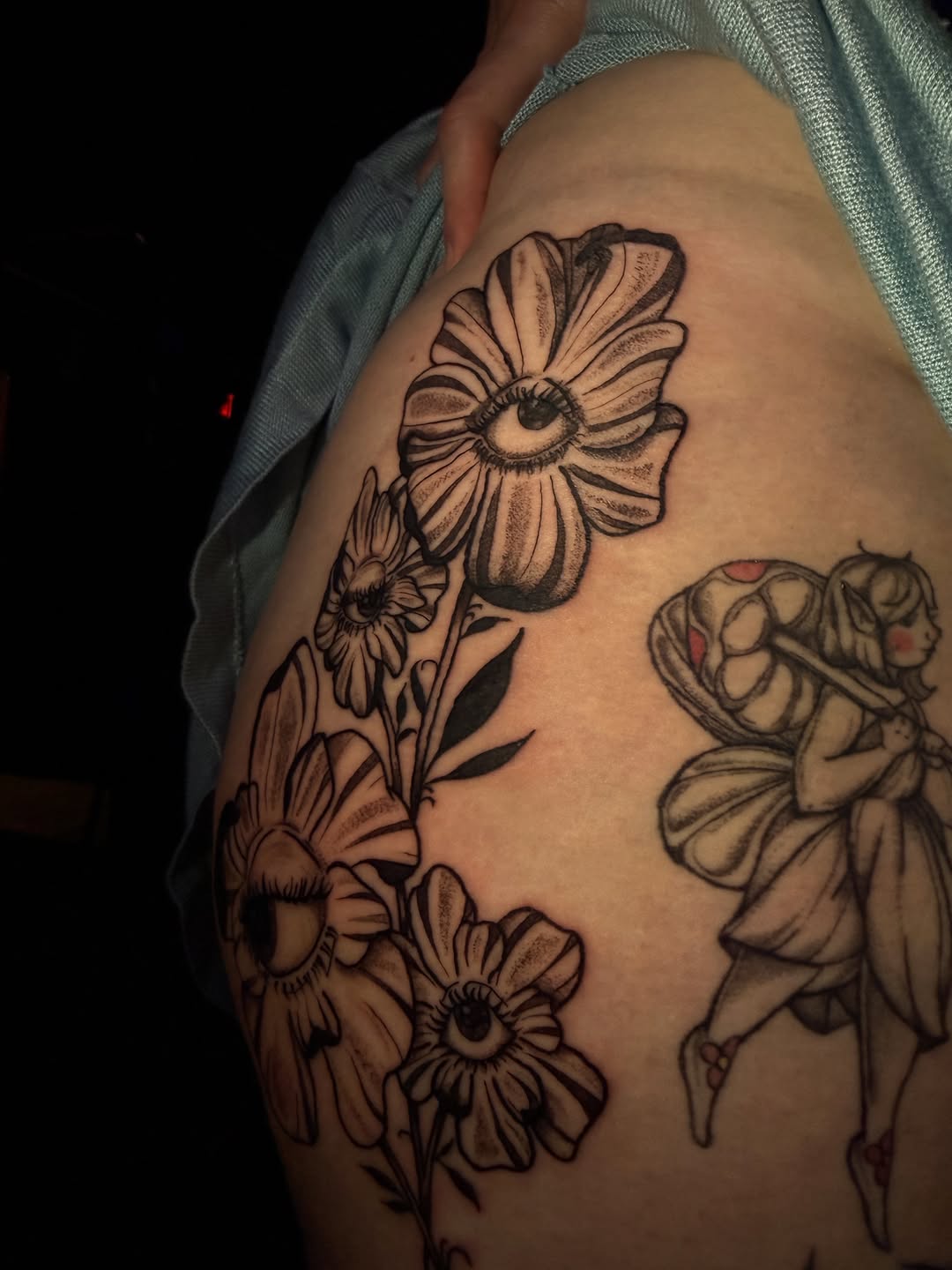 Flowers with eyes and a fairy dotwork tattoo on the thigh by licensed charlotte tattoo artist