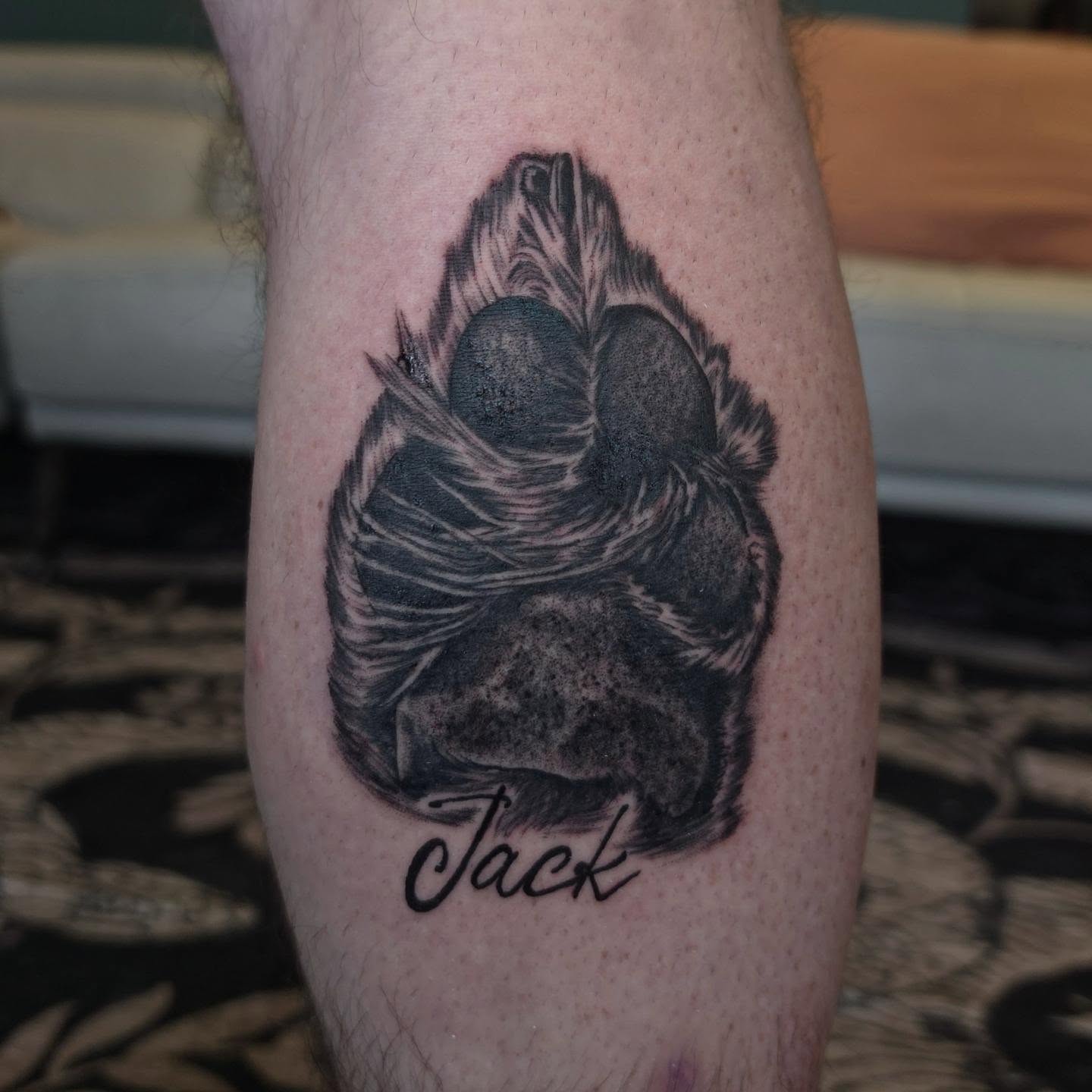 Dog paw print black and grey tattoo on the forearm by xavia