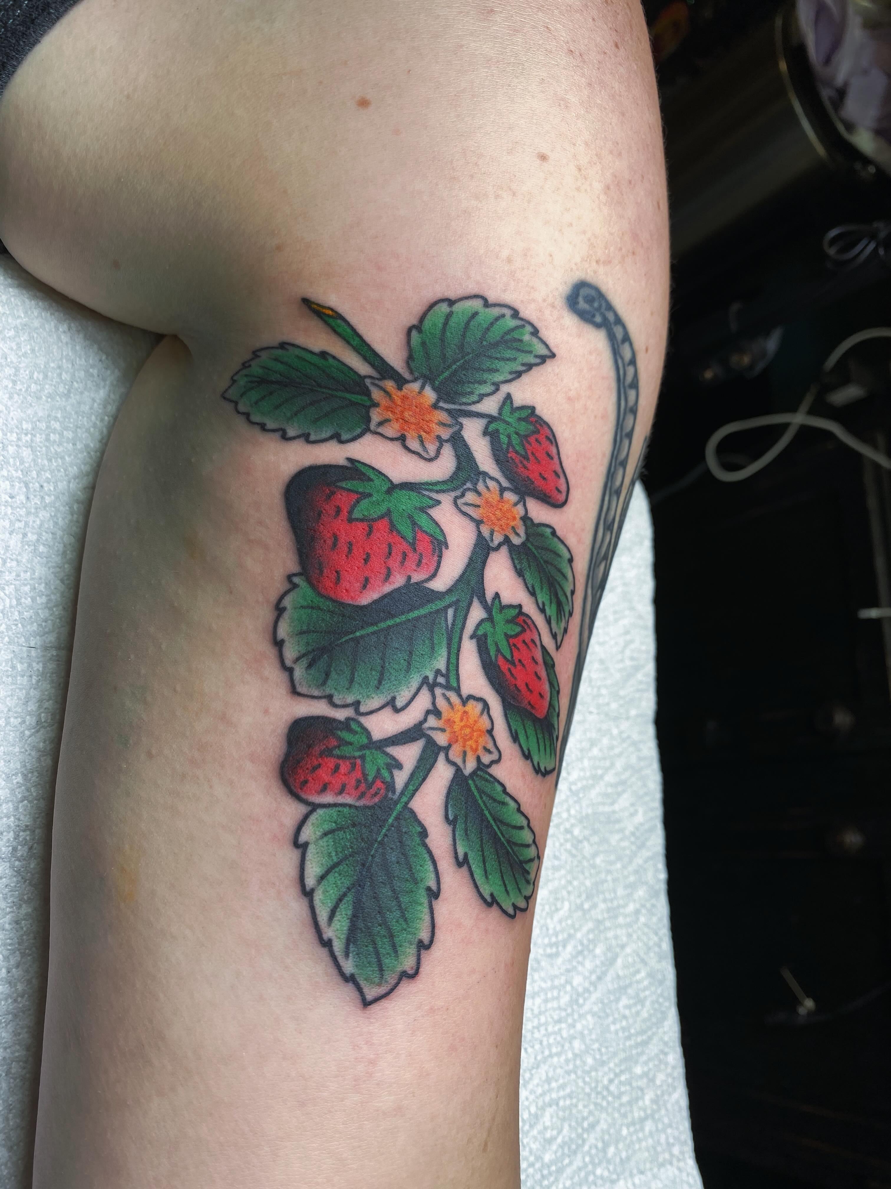 Strawberry plant American traditional tattoo on the upper arm by Houston tattoo artist
