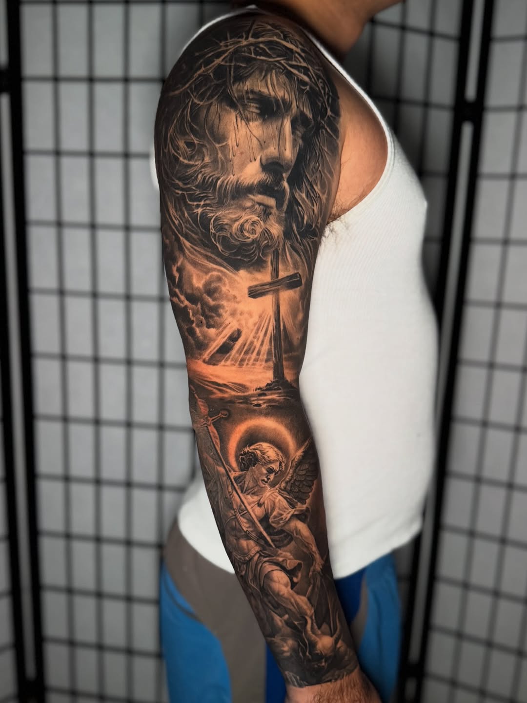 Jesus and Archangel Michael realism tattoo on the forearm by Anthony Ramirez
