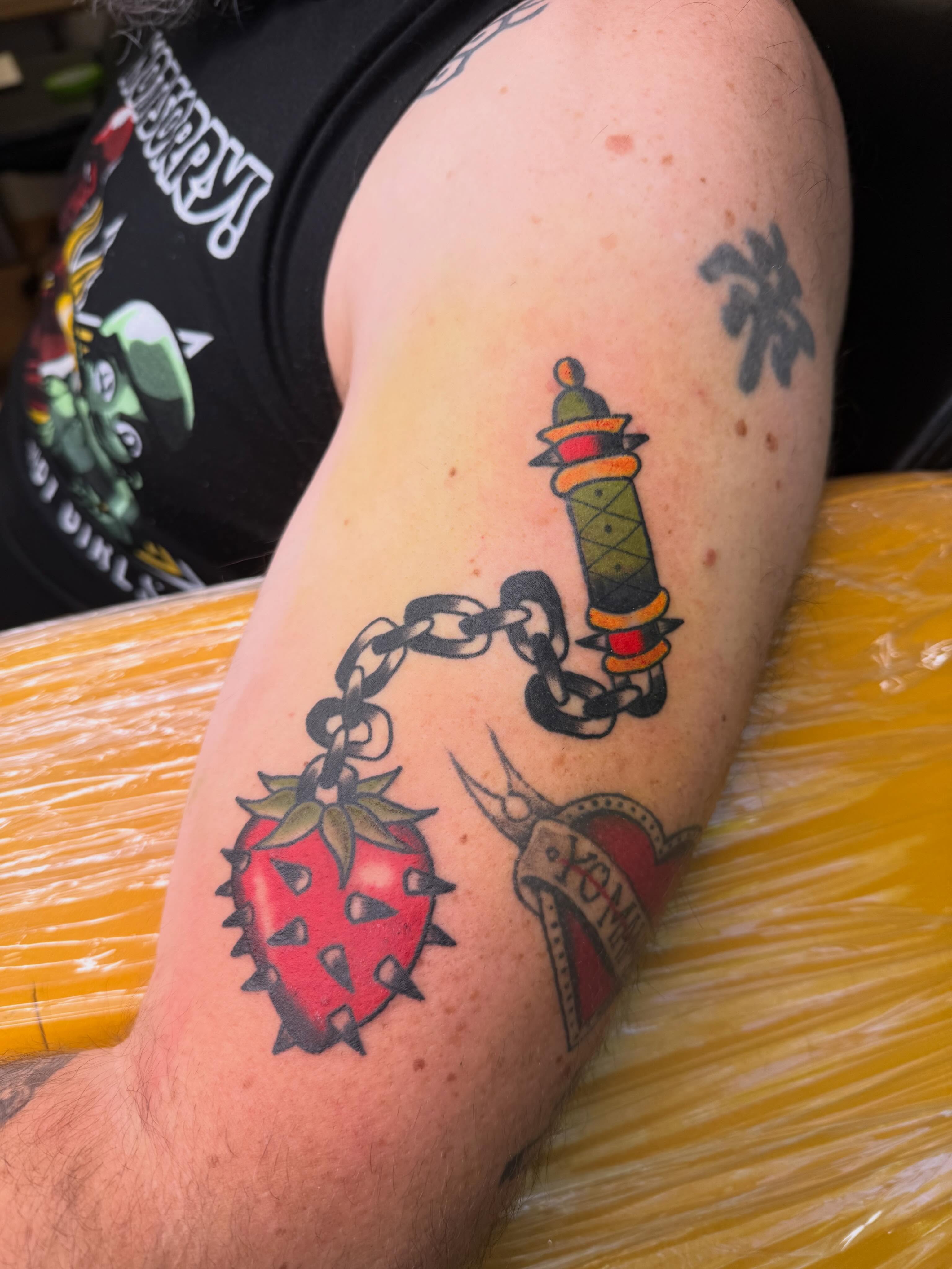Strawberry, dagger, chain American traditional tattoo on the forearm by Liz🗡️Fort Collins🗡️Tattoo Apprentice