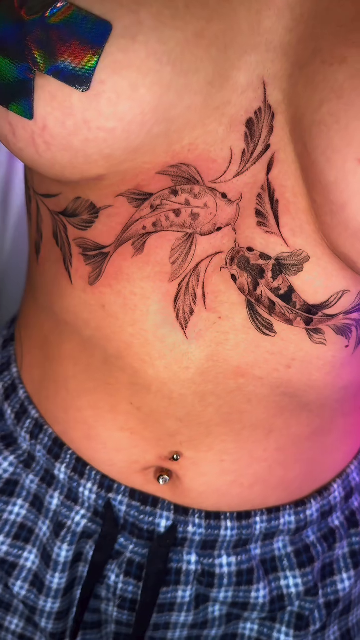 Koi fish and foliage chest piece fine line tattoo on the chest by Monica Gonzalez