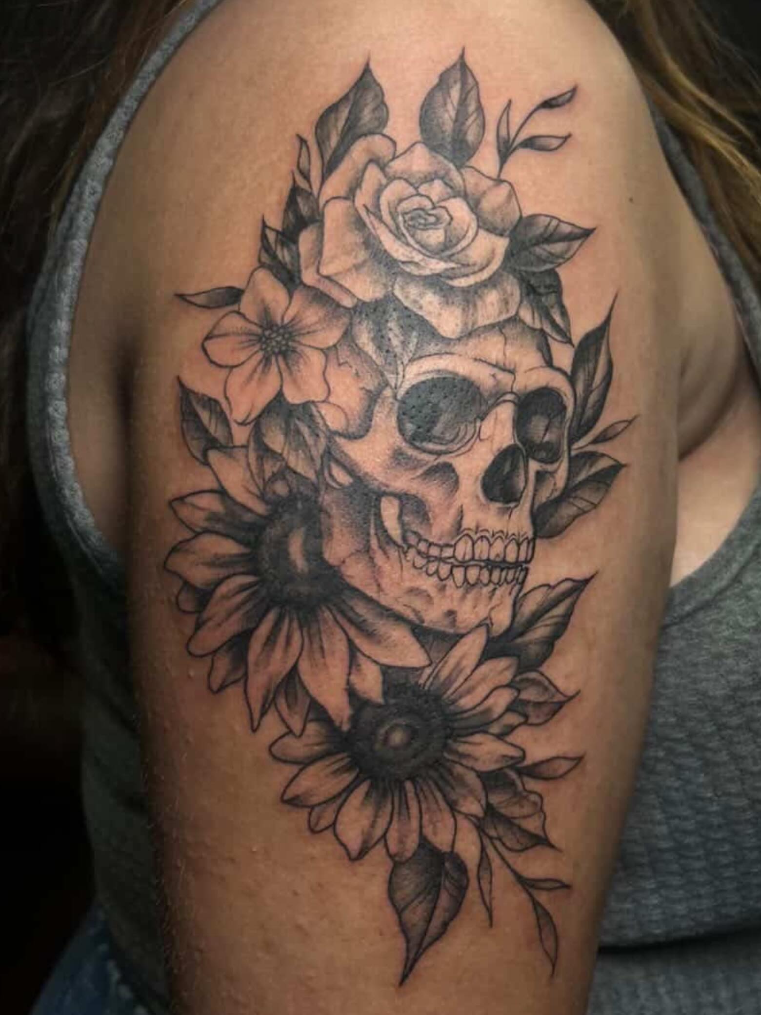 Skull and flowers realism tattoo on the shoulder by DFW