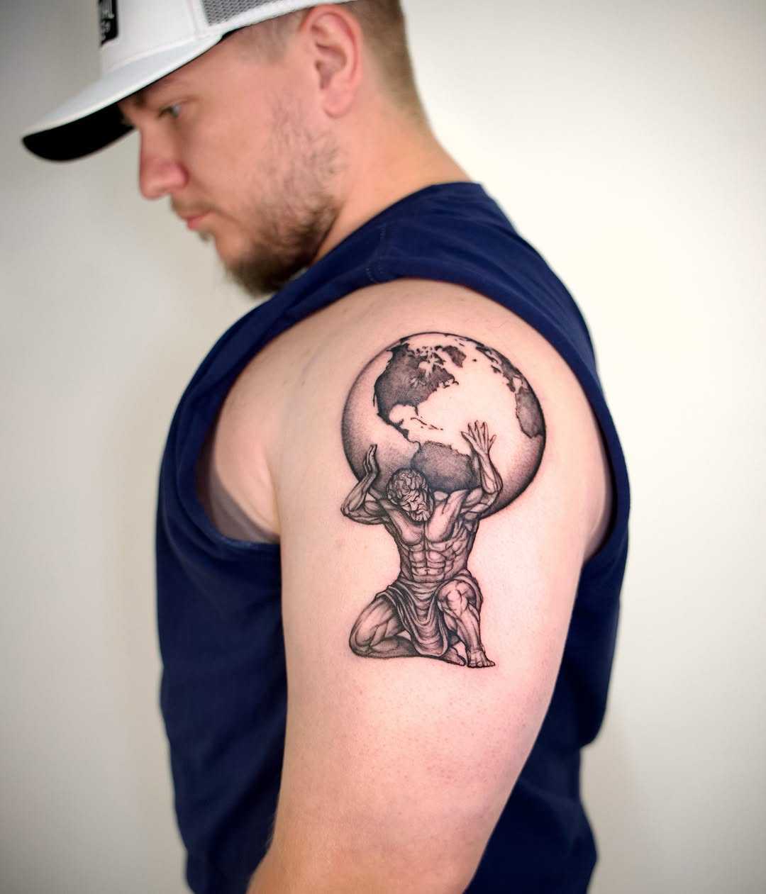 Man holding globe black and grey tattoo on the shoulder by @lovechasetattoo