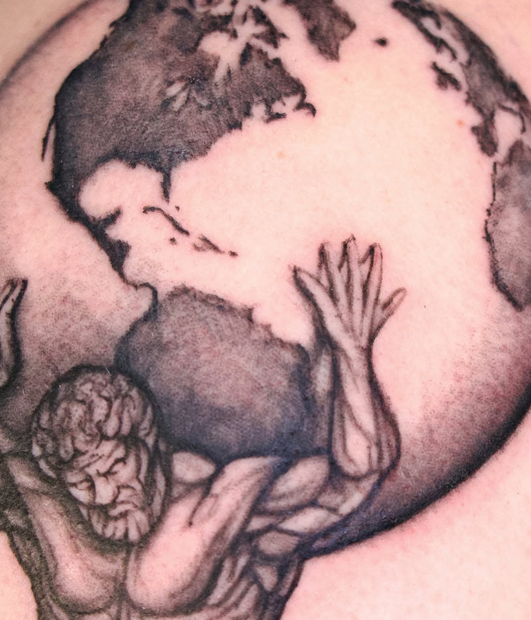 World map black and grey tattoo on the torso by @lovechasetattoo