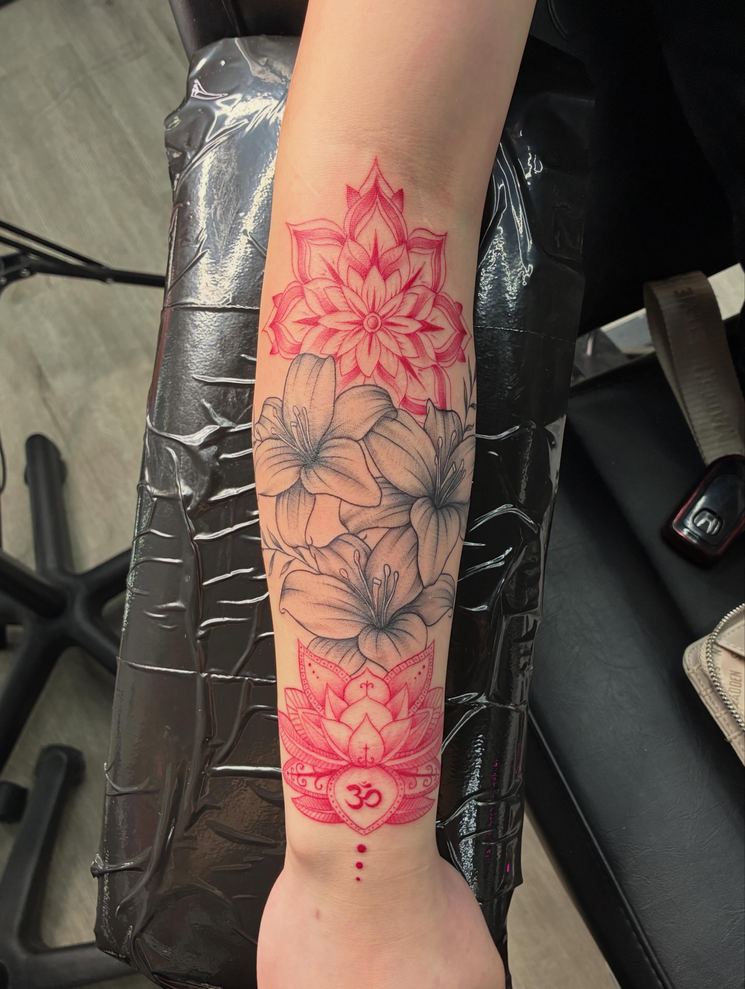 Lotus flower and floral arrangement geometric tattoo on the forearm by Tattoos by Hailey