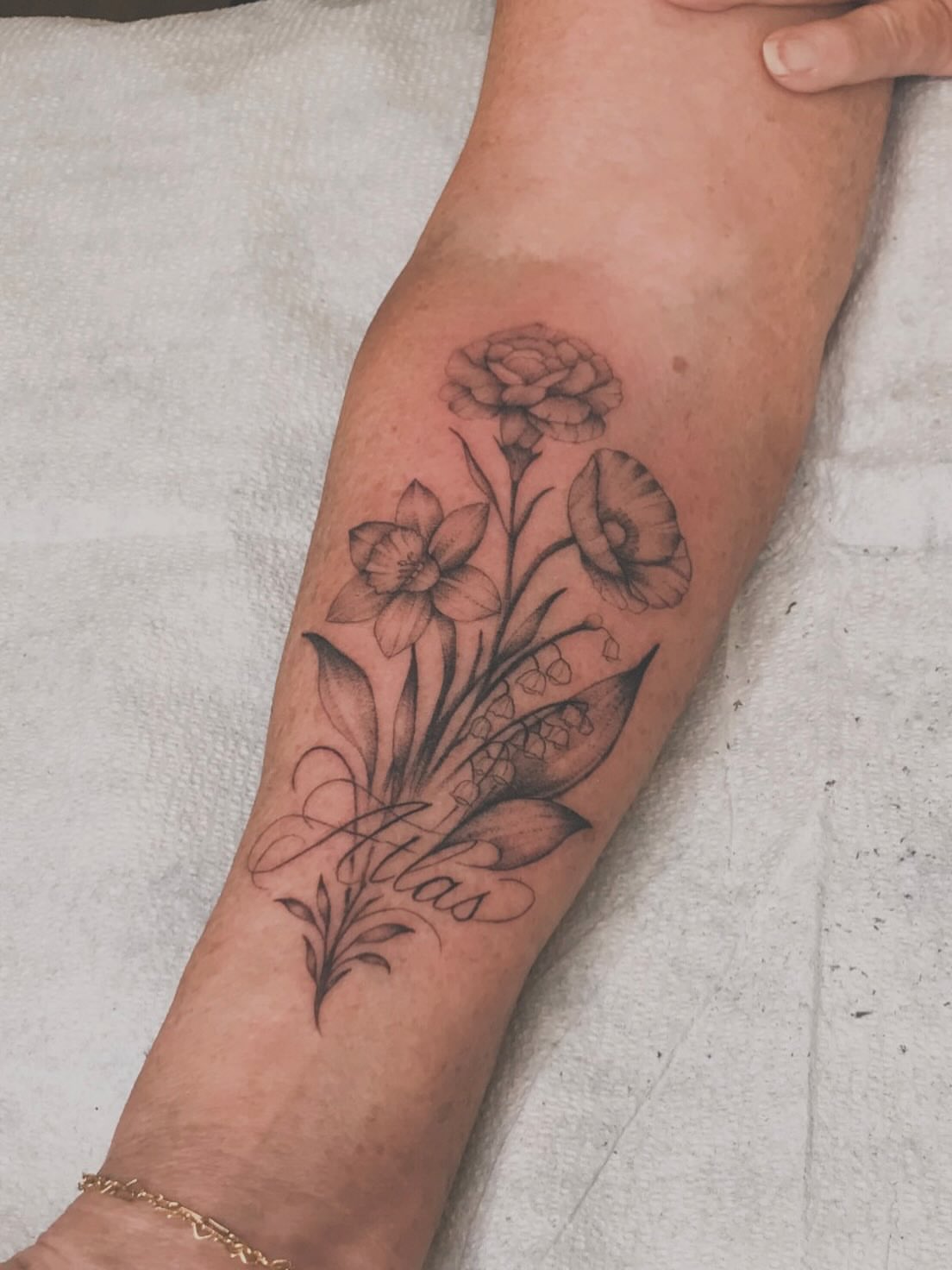 Floral bouquet black and grey tattoo on the forearm by Cody Mason