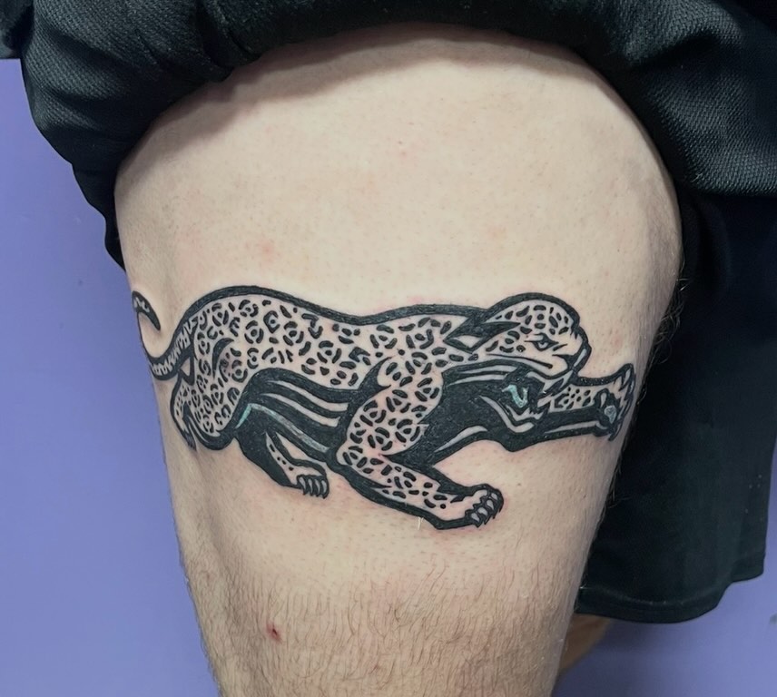Crouching leopard realism tattoo on the thigh by Mark Calloway