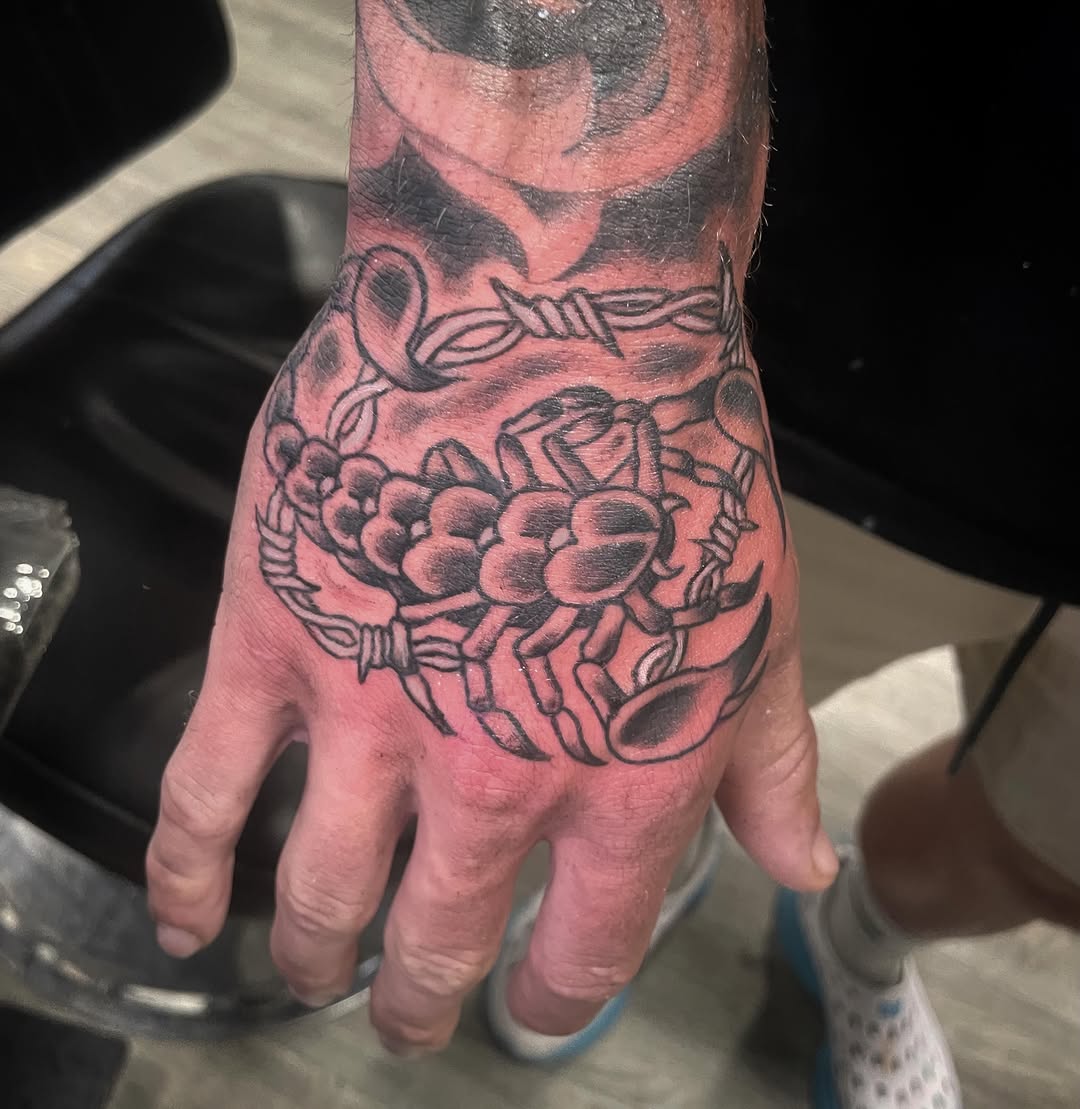 Scorpion and barbed wire blackwork tattoo on the hand by Logan Casimir