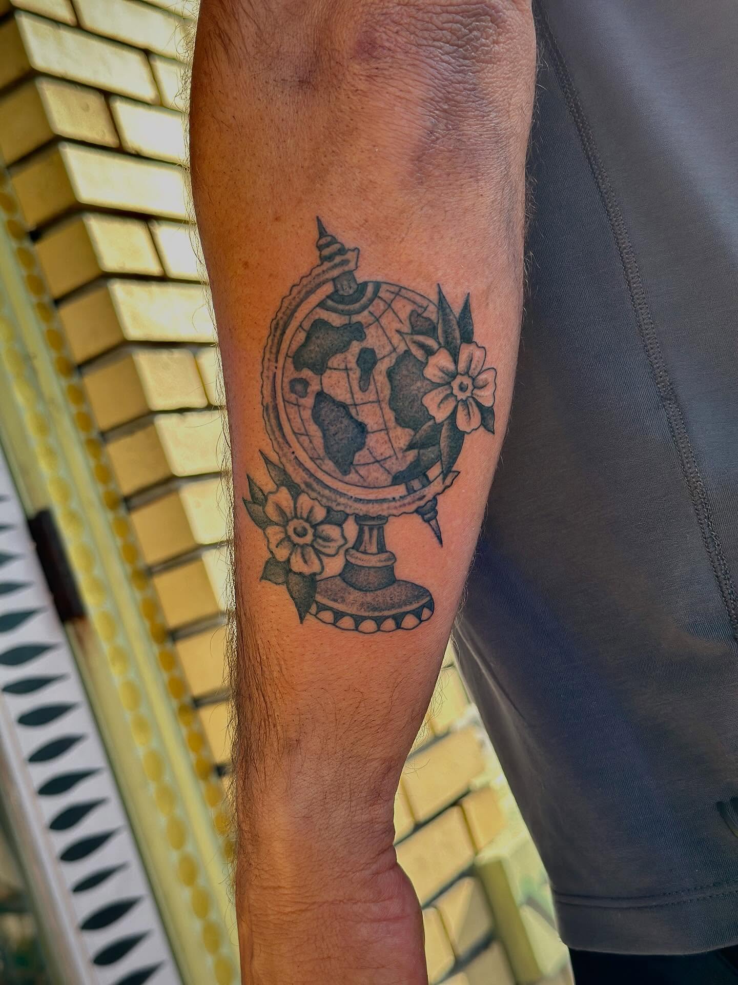 Globe with flowers black and grey tattoo on the forearm by Jared Allen, Saint Petersburg, Florida