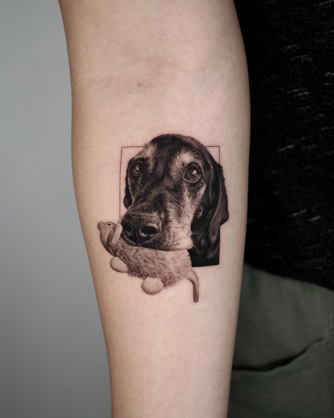 Dog with toy realism tattoo on the forearm by LA Tattoo Yeono