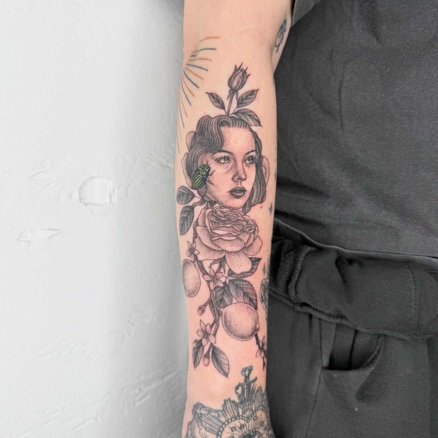 Woman with roses black and grey tattoo on the forearm by Rose