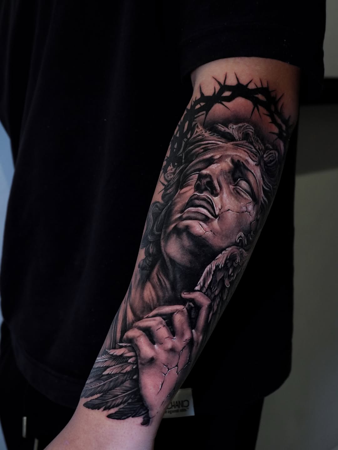 Angelic figure with crown of thorns realism tattoo on the forearm by Alberto Marrero